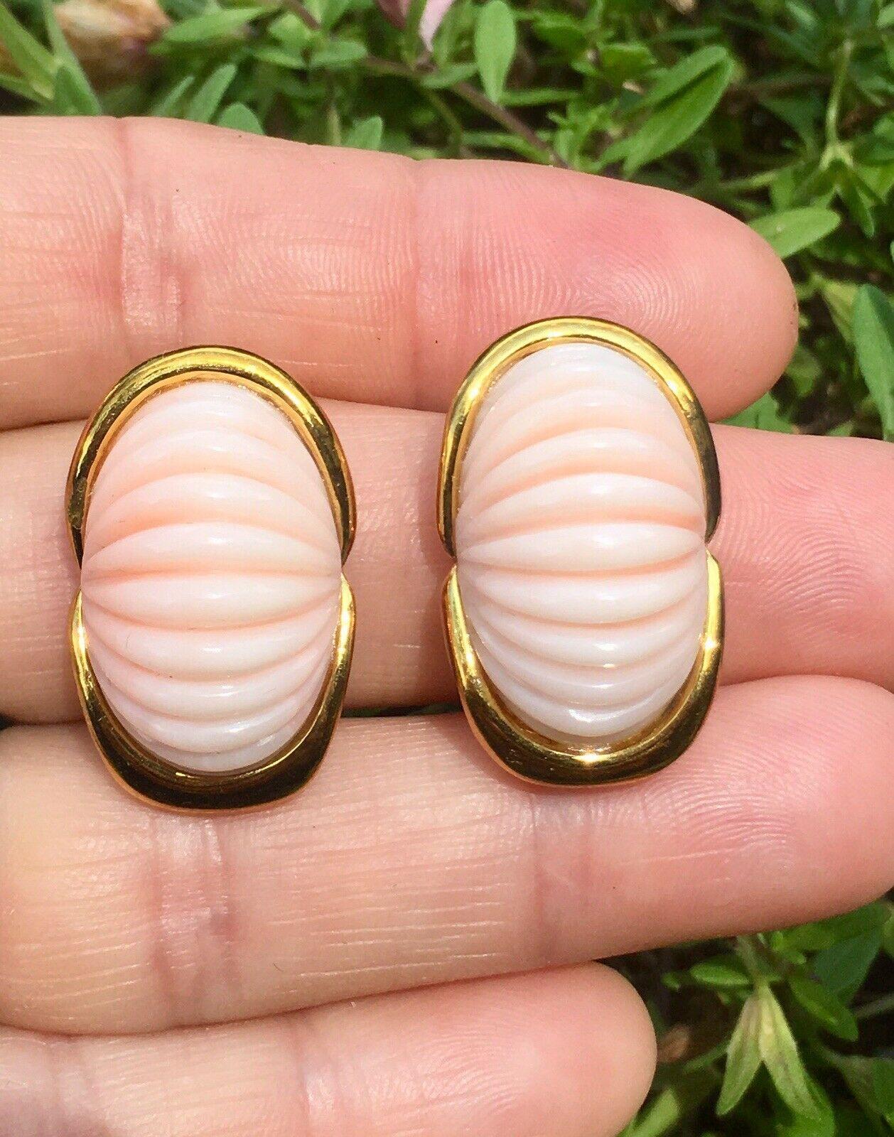 These beautiful Trio designer earrings feature two stunning large carved angel skin coral cabochons set in a beautiful framework of 14 karat gold.  The earrings are marked “14k” for gold purity on the back of the piece, as well as the designer