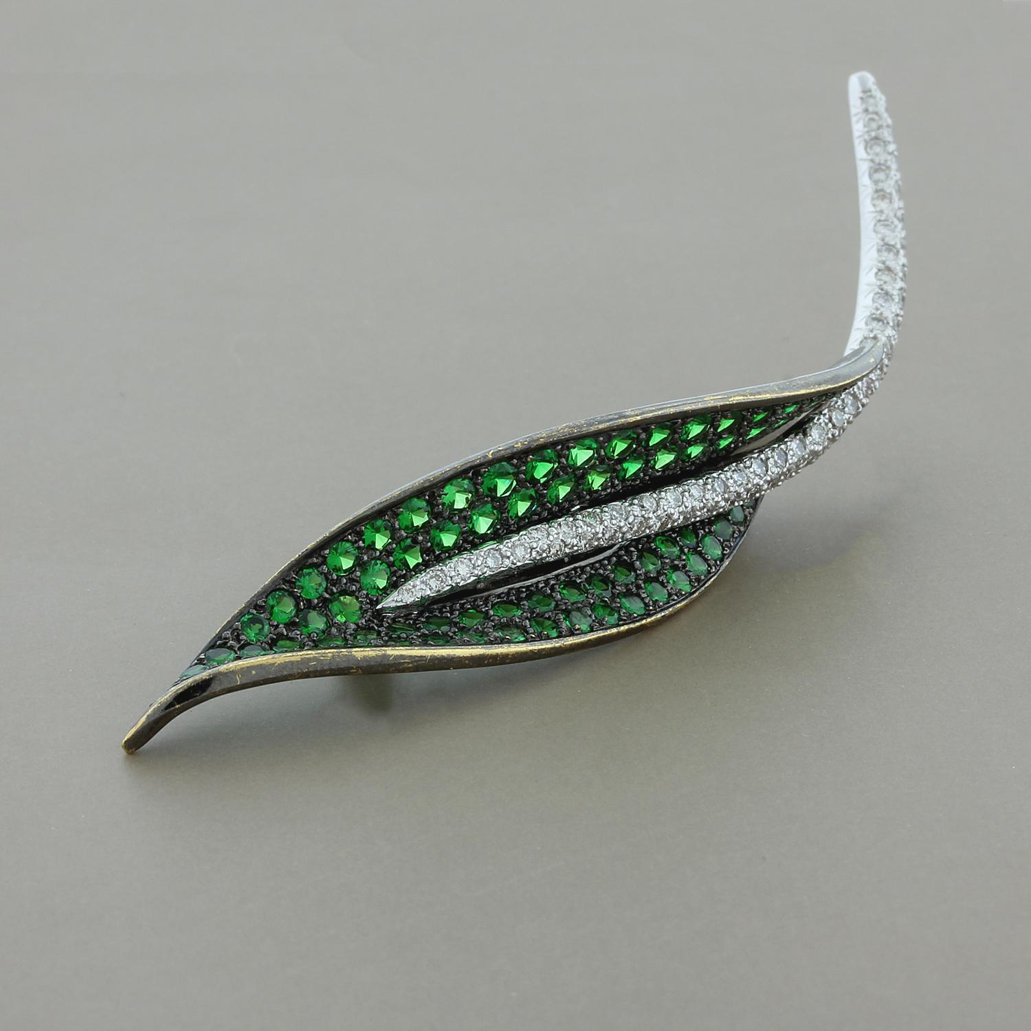 This elegant estate leaf brooch stands on its own. With 3.19 carats of true green round cut tsavorite in an 18K black rhodium setting. The rib of this lovely leaf is studded with 1.00 carat of VS quality colorless diamonds. The round cut pave set
