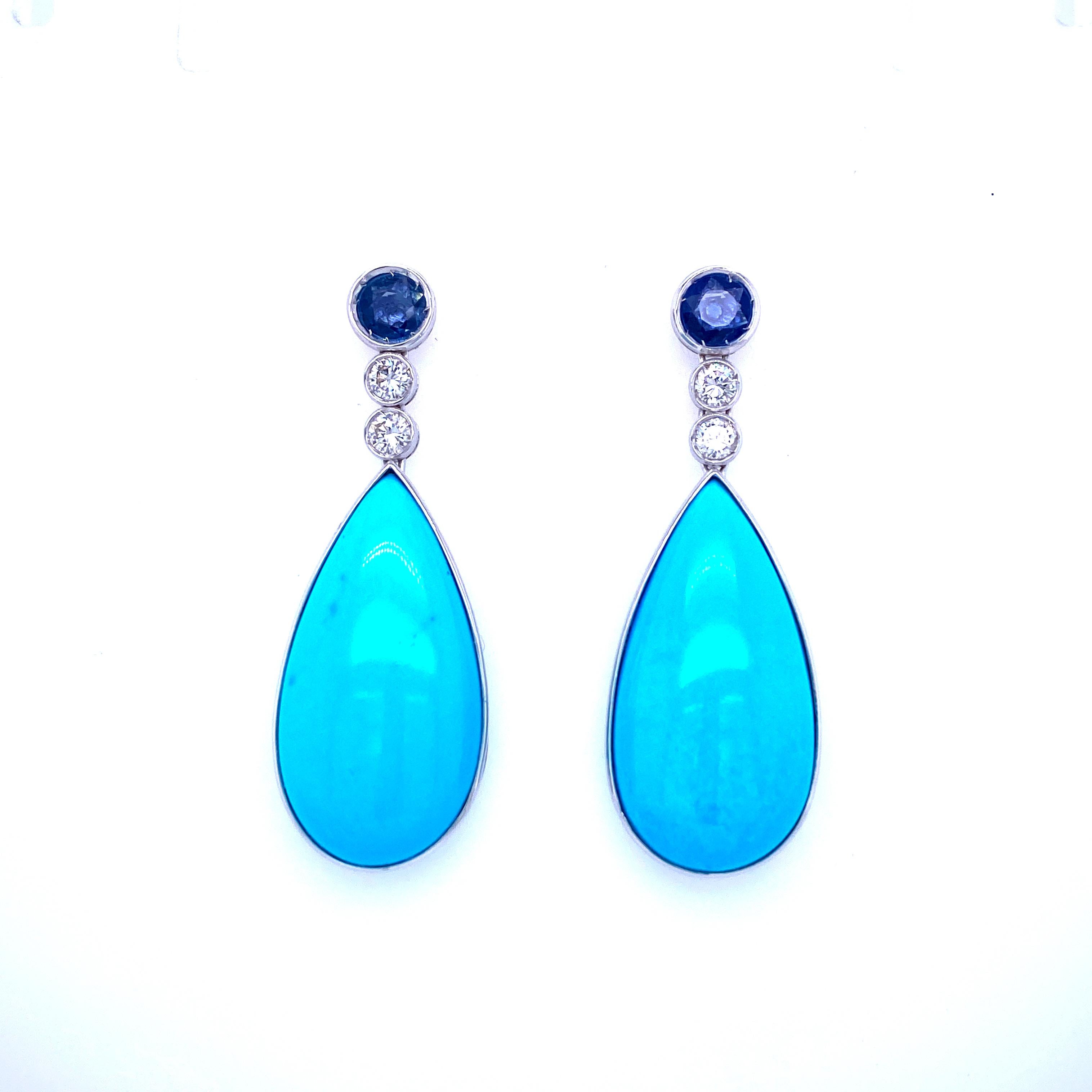 Stunning pair of 18k white gold hand-made pendant earrings, dated 1980, origin Italy.
Each earring features a large Natural drop flawless Turquoise, great quality, very rare today, set with 1.20 carats of Natural Sapphires and sparkling round
