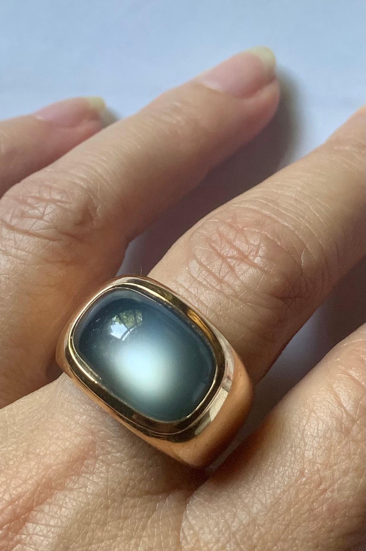 Organic fluidity is aptly descriptive of this elegant estate Vhernier 18K gold and large cabochon moonstone ring. The mysterious silvery grey moonstone pairs perfectly with the substantial, well rounded gold setting which fits seamlessly on the