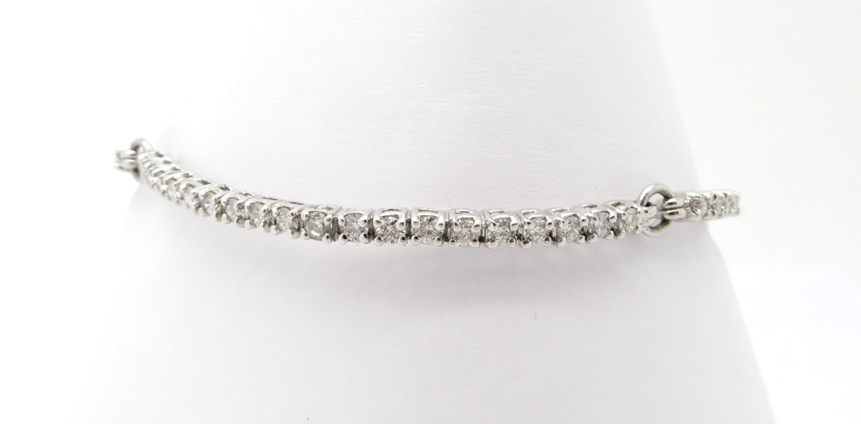 Estate 14K white gold round diamond bracelet. Showcasing 55 round brilliant cut diamonds, each four prong set in three hard sections weighing a combined total of 2.45 carats. Diamond grading: color grade: G – H. Clarity grade: VS1 – VS2. The