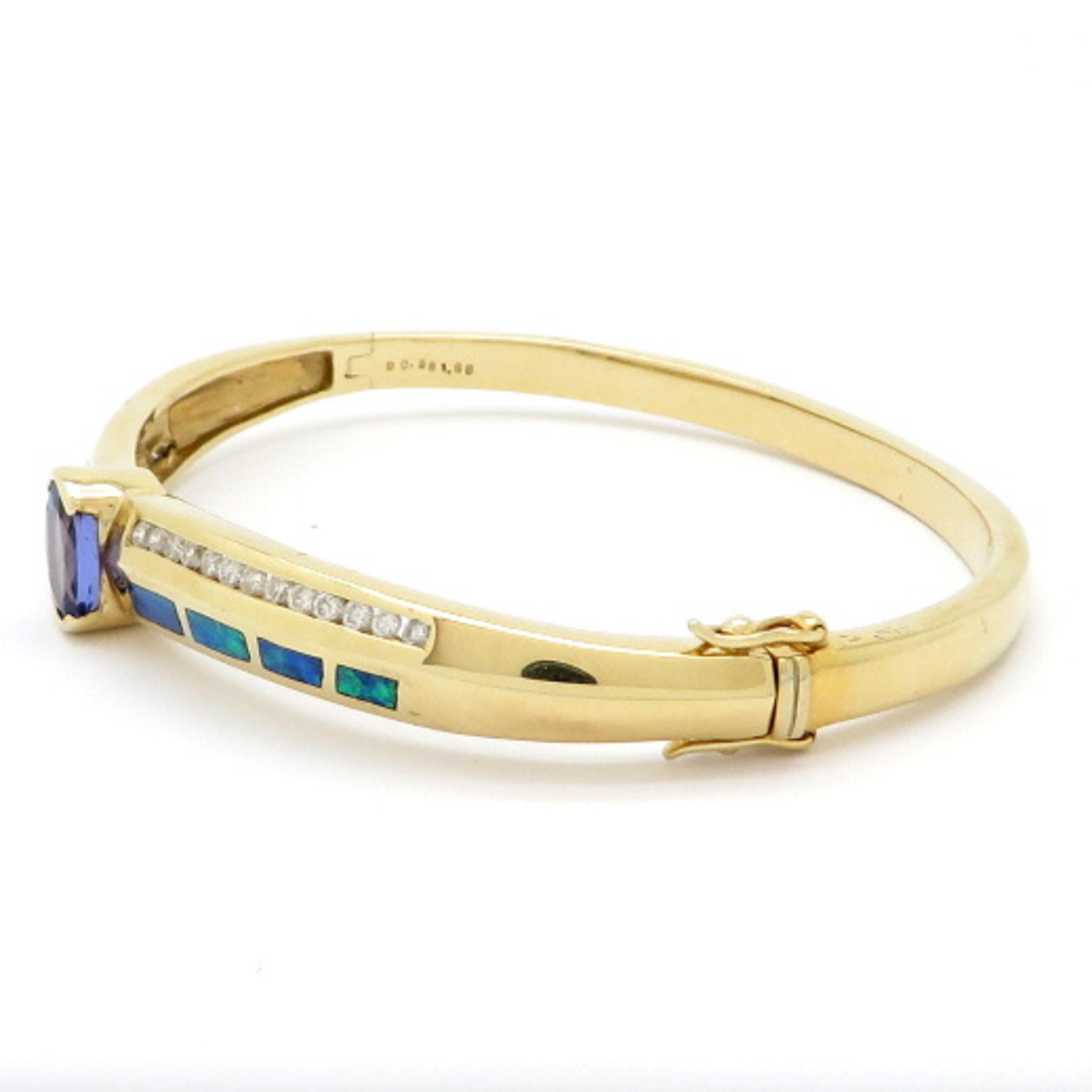 Estate 14K yellow gold tanzanite, opal and diamond bracelet. Showcasing 26 round brilliant cut diamonds weighing a total of 0.58 carats, having H color grade and SI2 clarity grade. Centering one oval tanzanite, bezel set, weighing 1.88 carats. The