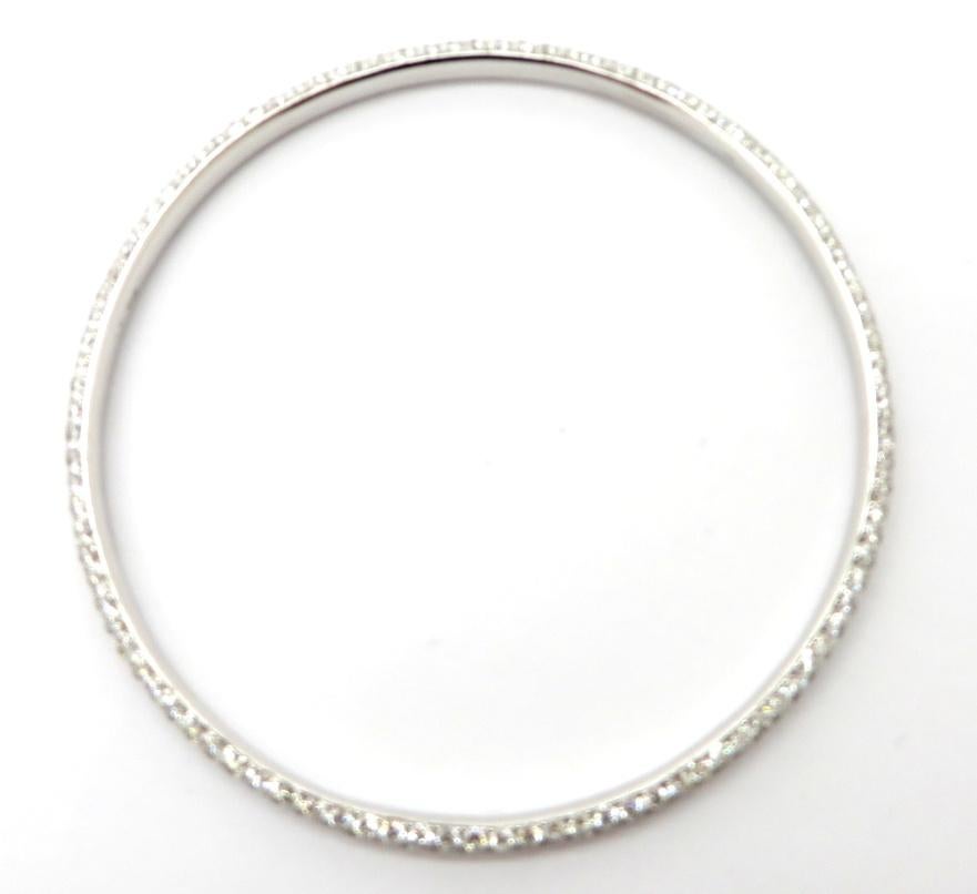 Estate vintage 18K white gold pave round diamond bangle bracelet. Showcasing 303 bead set round brilliant cut diamonds weighing a combined total of 9.63 carats. Diamond grading: color grade: G – H. Clarity grade: VS1 – VS2. The inner diameter