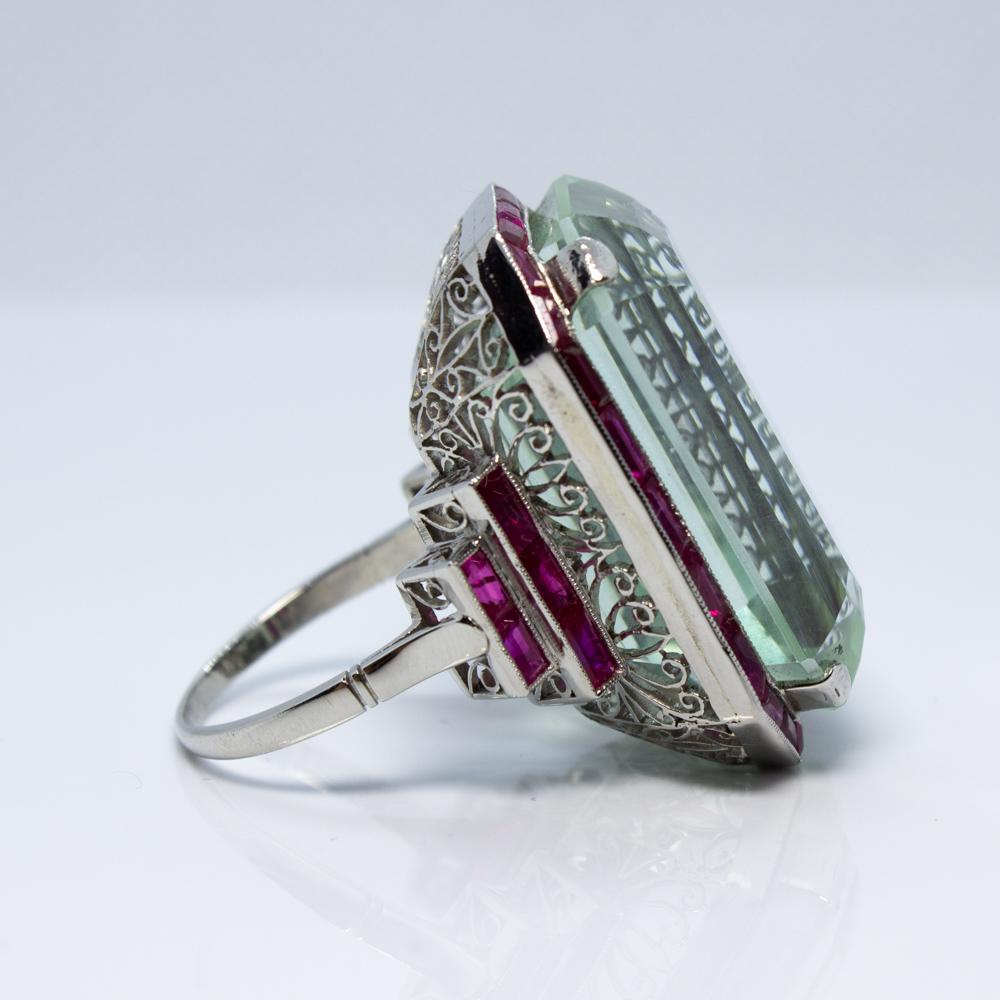 For sale is a lovely estate Platinum Ruby and Large Aquamarine Ring!
Showcasing one (1) Emerald Cut Aquamarine, prong set, measuring 28.00 x 18.08 x 14.14 mm,
weighing approximately 49.45 carats. 
Accenting the ring are thirty-four (34) natural fine