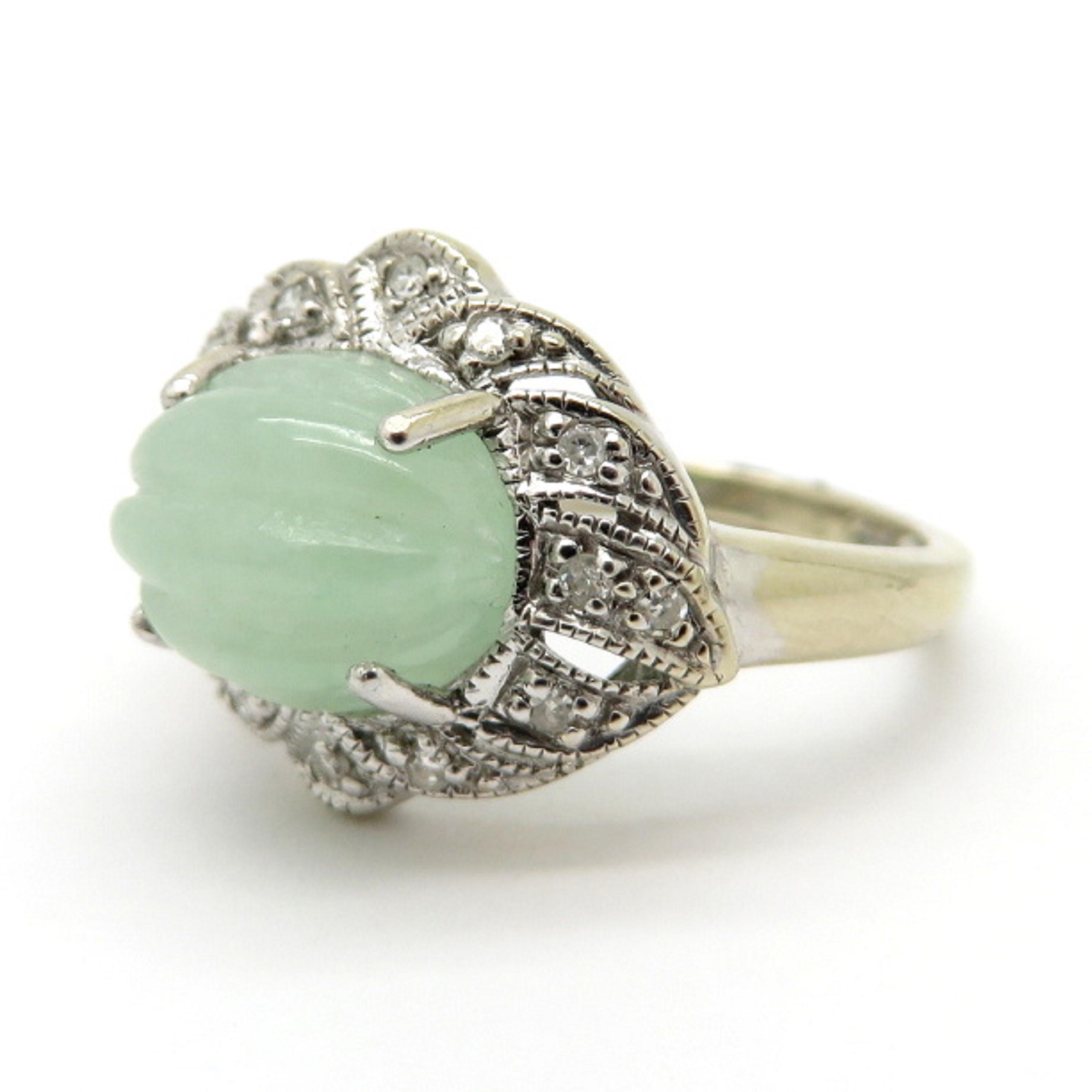 For sale is an estate Oval Jade Ring with Round Diamonds set in 14K White Gold!
Showcasing one oval carved light green natural Jade accented by 14 Round Brilliant Cut bead set diamonds, weighing a total of 0.12 carats.  
The ring is a finger size 6