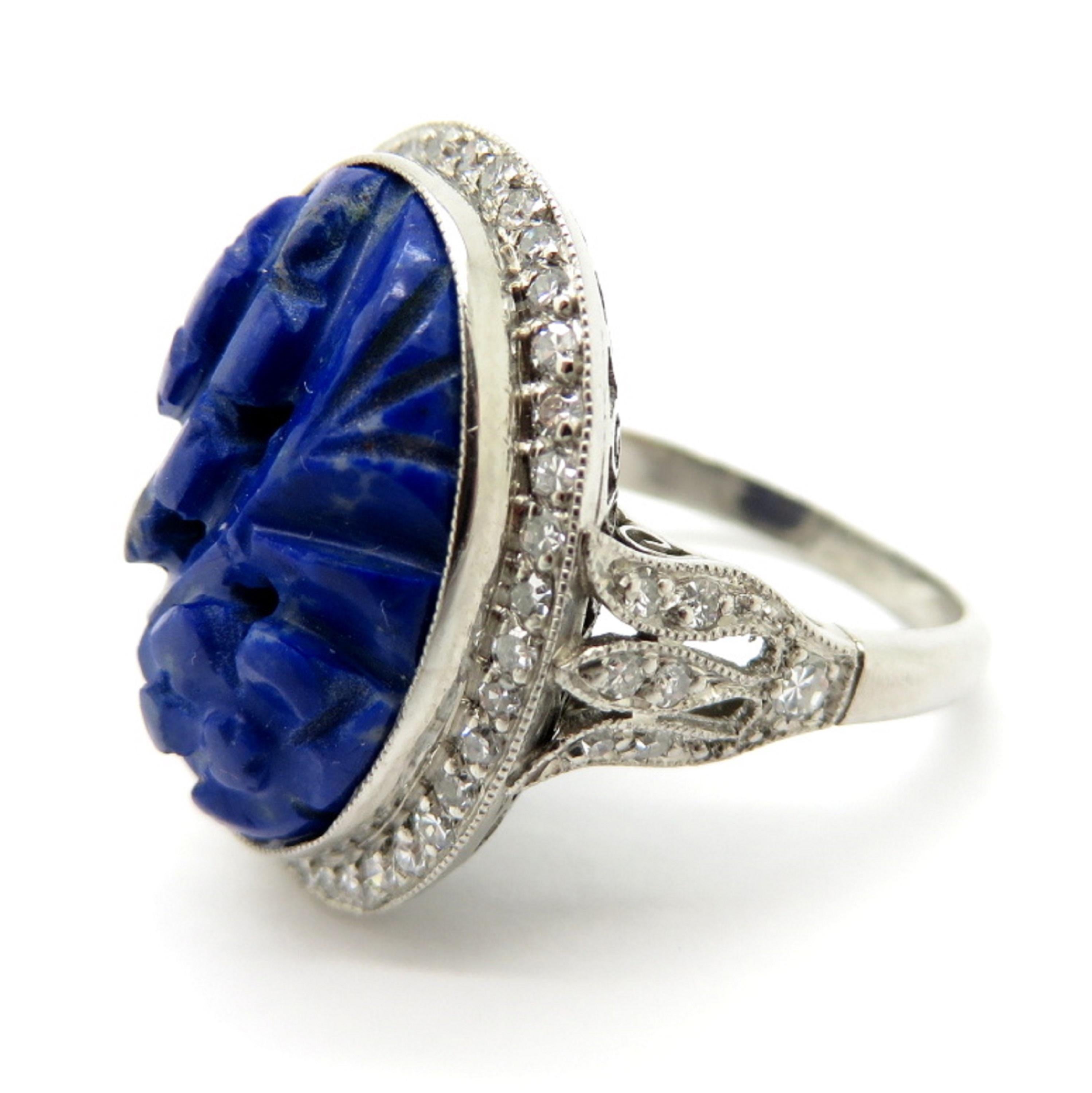 For sale is a lovely estate carved Lapis Lazuli and diamond halo ring!
Showcasing one (1) oval shaped Lapis Lazuli carved in a beautiful floral motif.
Surrounding the lapis lazuli in a halo style are (53) Single Cut diamonds, with various