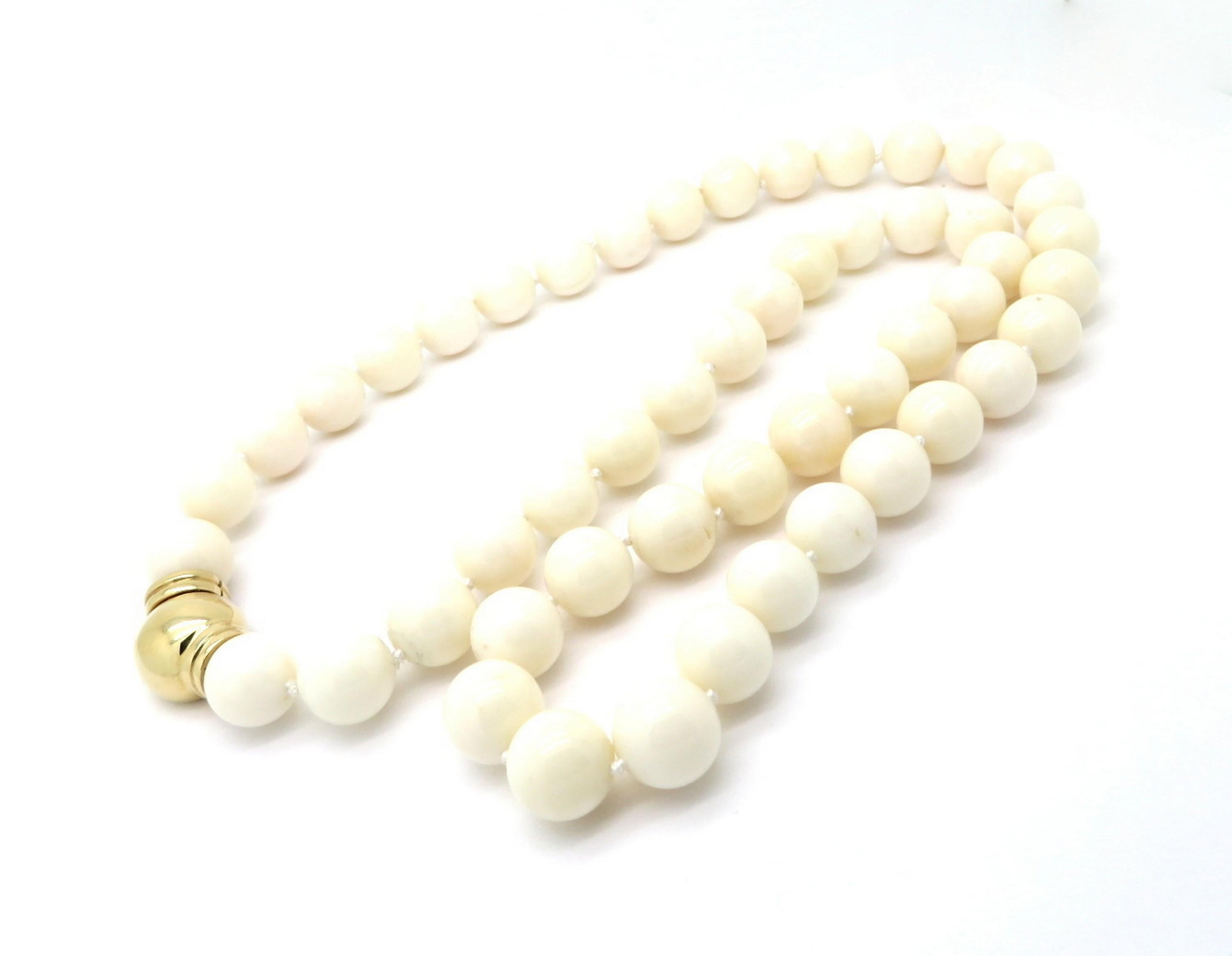 Estate beaded white coral long necklace. Featuring 51 round white coral beads each measuring an average of 14 mm. The necklace measures 30” inches long. It is secured with a 14K yellow gold rounded clasp with a push hinge closure.  The total net