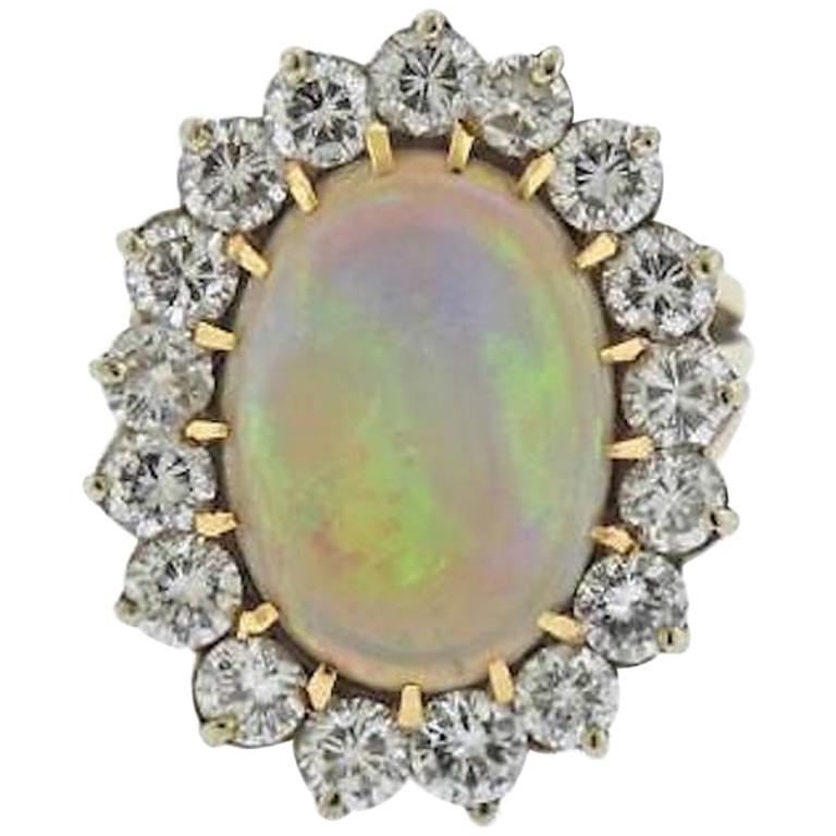 This stunning ring is comprised of a gorgeous large 13 carat opal set in 14k yellow gold, surrounded by a striking large diamond halo 
composed of 3.00 carats of G-H VS brilliant cut diamonds.

The ring top is 27 mmm in length and 24mm wide and the