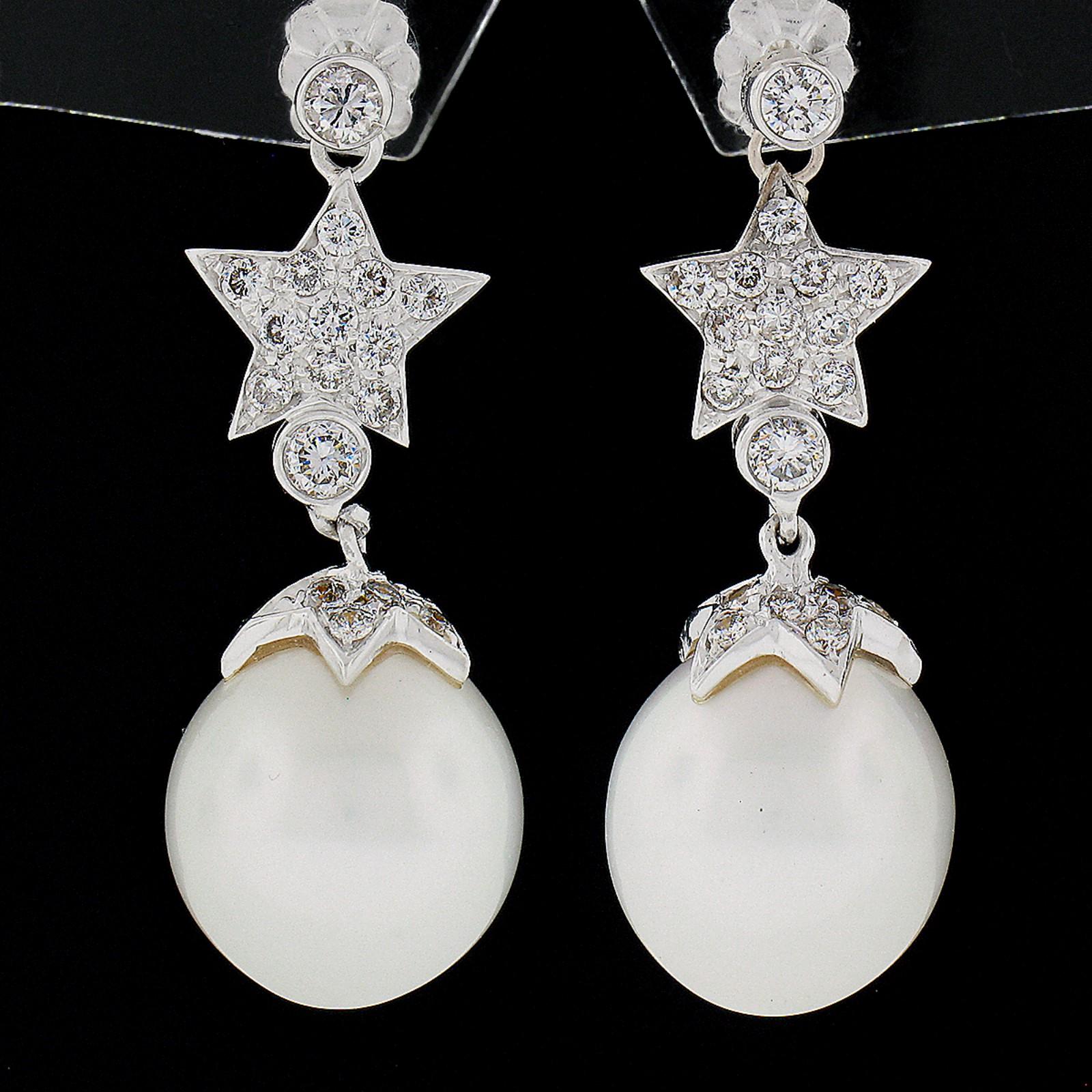 This fancy pair of diamond and pearl dangle earrings is very well crafted in solid 18k white gold. They feature a truly elegant star design that is completely covered with round brilliant cut diamonds and an ovalish-shape white pearl that together