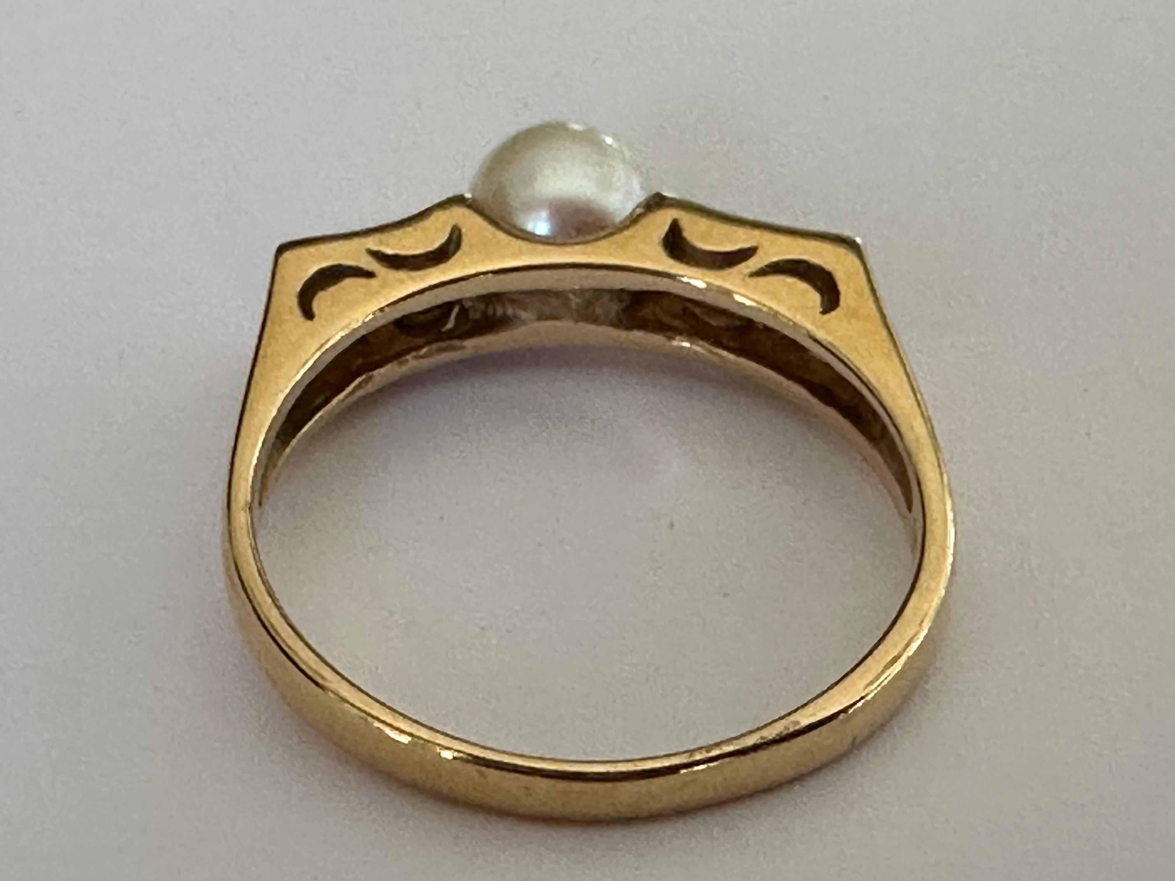 This ring features a 6mm white pearl simply and elegantly presented between two pairs of round brilliant-cut diamonds totaling approximately 0.10 carats. Set in 14K yellow gold. 