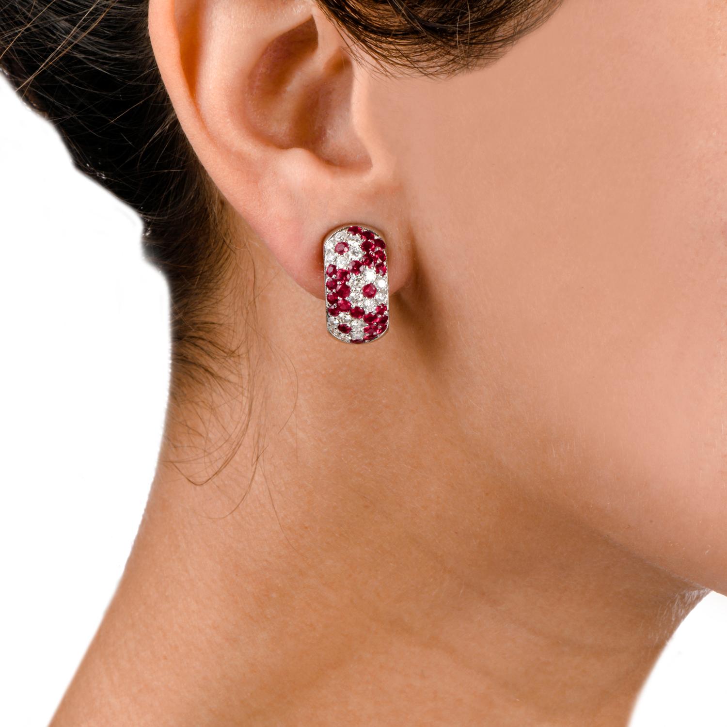 These Diamond and Ruby hoop earrings were inspired with a wide band pave flower motif and crafted in 18k gold weighing approximately 16.0 grams. The style in adorned with Ruby and Diamond flowered patterns and measure approximately 10.13mm x 19.73mm