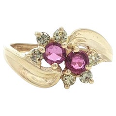 Anello a fascia bypass Petite in oro giallo, zaffiro rosa, diamante e fiore.