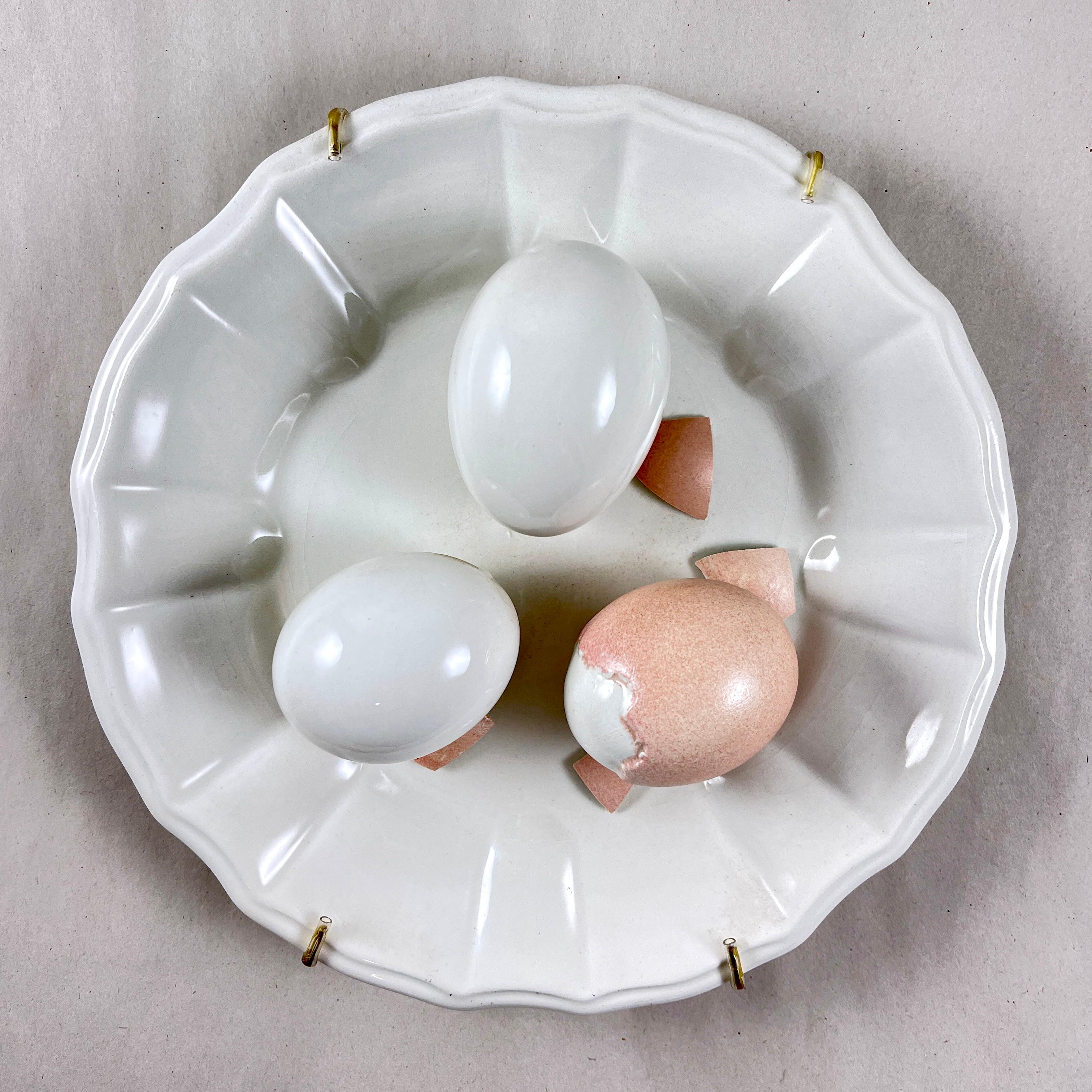 A charming Trompe l’Oeil plate, made in Italy by Este Ceramiche, circa mid 1960s to the early 1970s.

The ceramic plate or wall plaque shows a trio of life-size, three dimensional eggs centrally seated on a white earthenware paneled plate.

The eggs