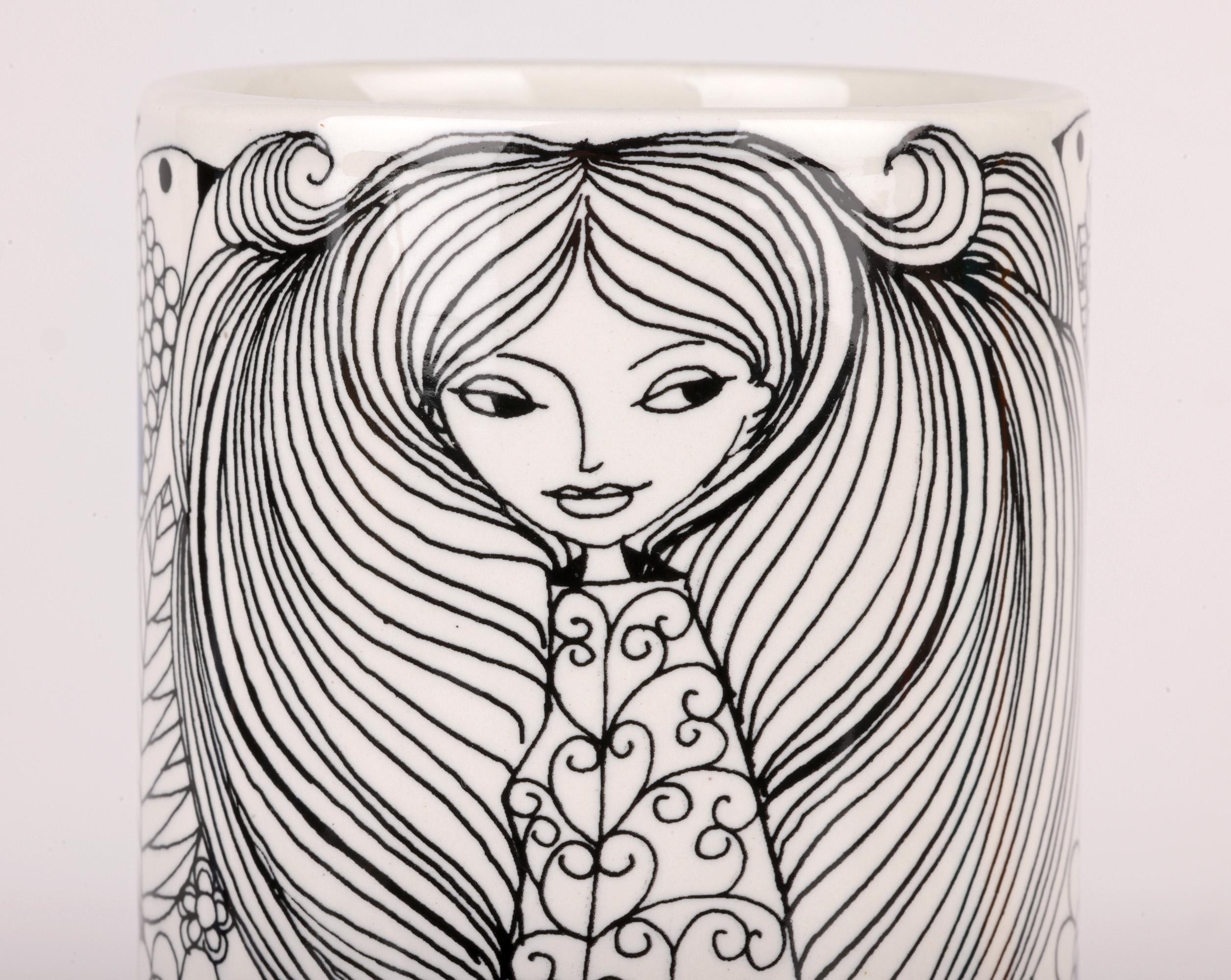 Un elegante vaso di porcellana finlandese della metà del secolo scorso, decorato con una giovane donna dai capelli fluenti da Esteri Tomula per Arabia. Il vaso, finemente realizzato, ha una forma cilindrica alta ed è decorato con un motivo