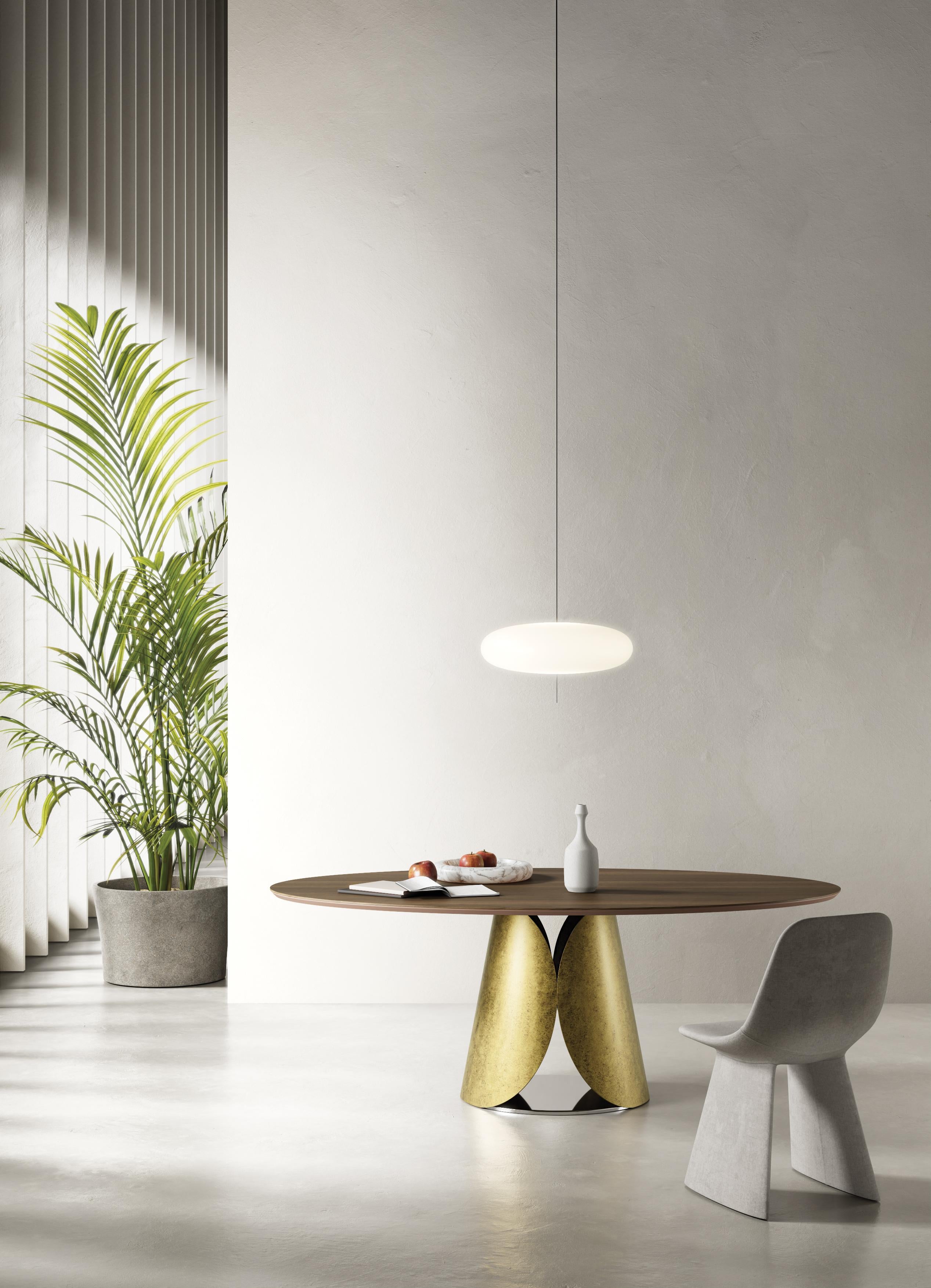 Estia Dining Table by Chinellato Design
Dimensions: D 110 x W 200 x H 71 cm
Materials:
Top:  Canaletto Walnut.
Base: Black Patinated Gold Leaf finish.

In this table, graceful curves take center stage, exuding an enveloping softness that harks back