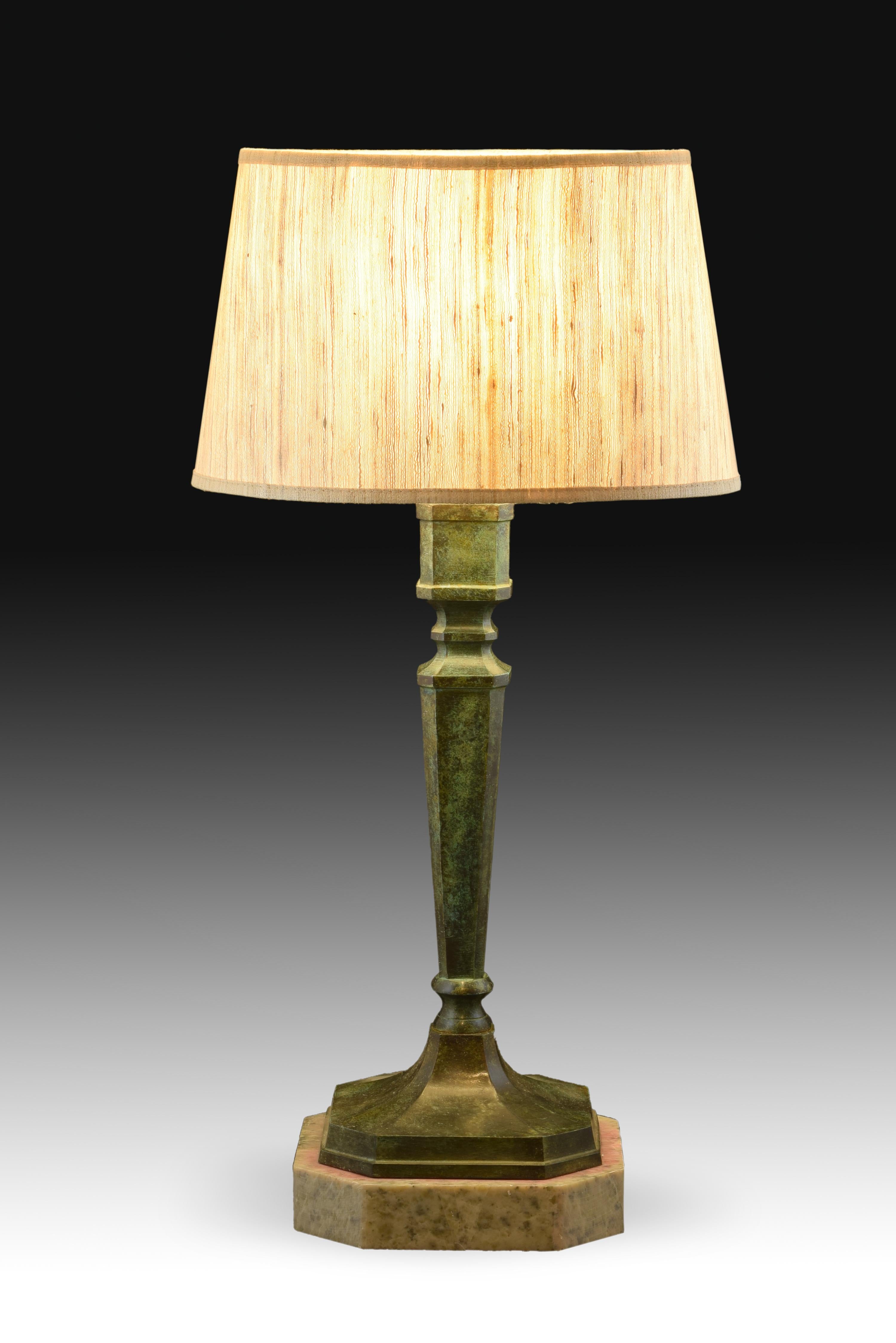 Table lamp in patinated bronze in the shape of a stipe. Without screen.
Marble base a marble base highlights the lamp, formed by a stipe divided into two parts by a central disc with concave moldings on each side. This type of pilaster, widely used