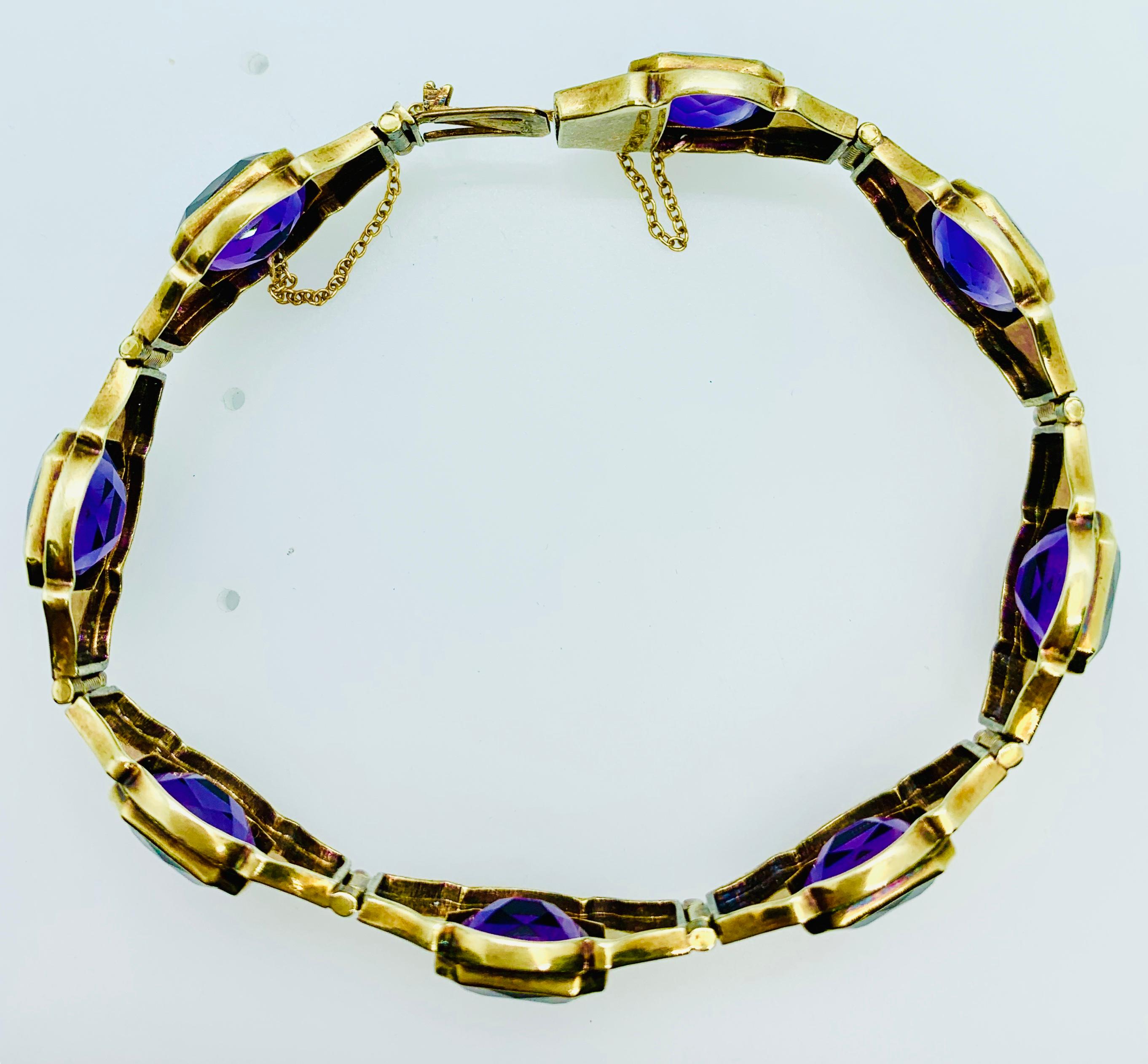 This gorgeous art deco bracelet features 8 sections that have beautiful and brilliant  cushion shaped amethyst stones at the center that are flanked by two green enamel strips on top and bottom and then black enamel and gold scroll work on either
