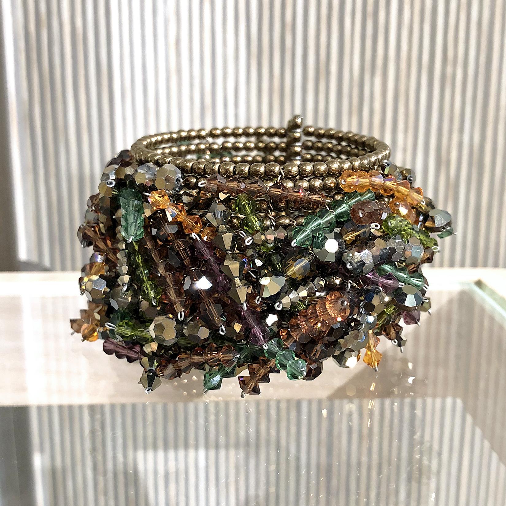 Chaos Cuff Bracelet handcrafted by jewelry artist Estyn Hulbert with thirteen rows of assorted swarovski crystals intricately strung on a yellow gold filled chain with a bronze bead base. Very flexible, and easily stretches to open and close