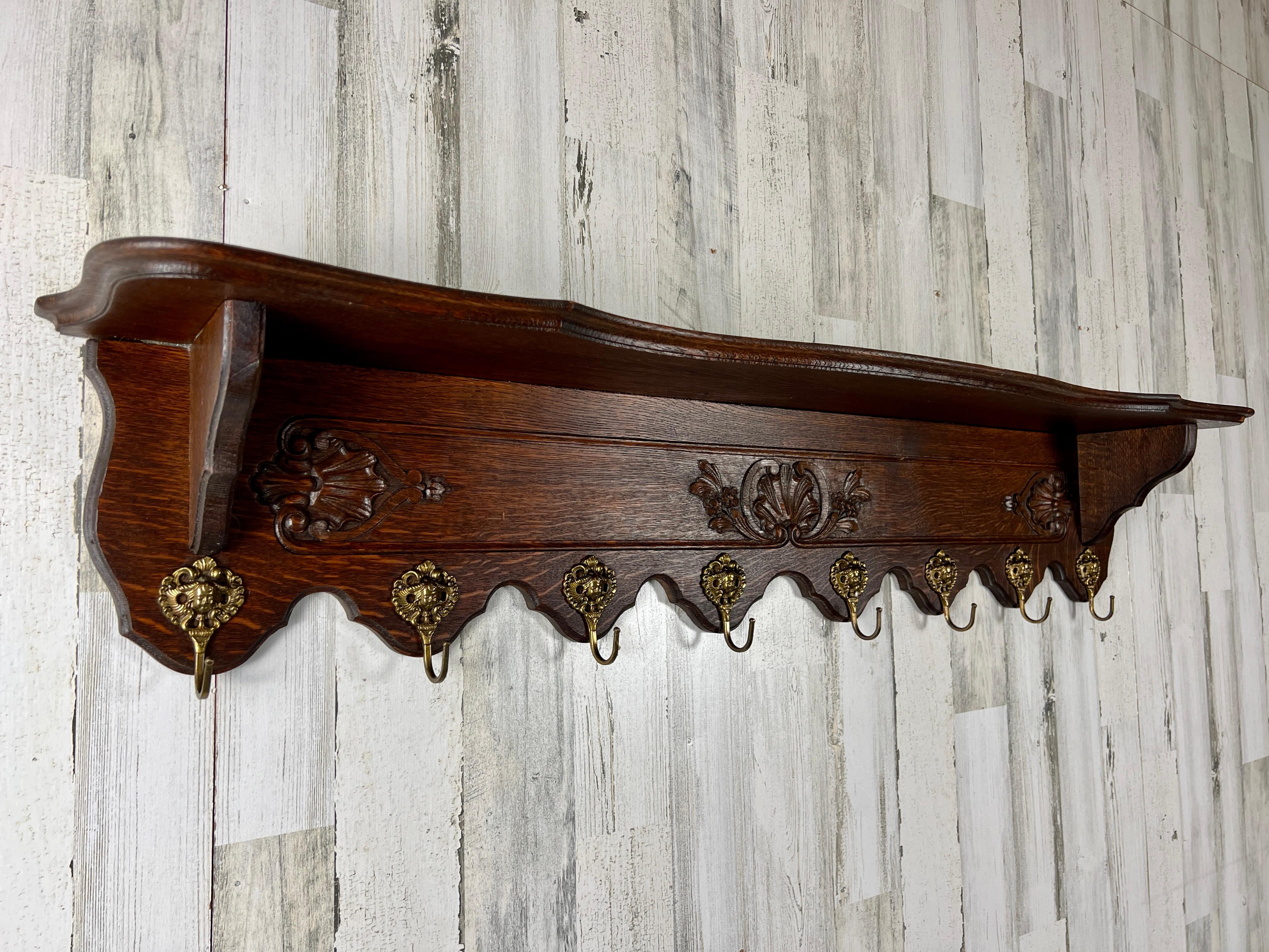 Sculpted oak with ornate brass hooks that can be used for hanging pot and pans or coats and hats. Made in France 1920.