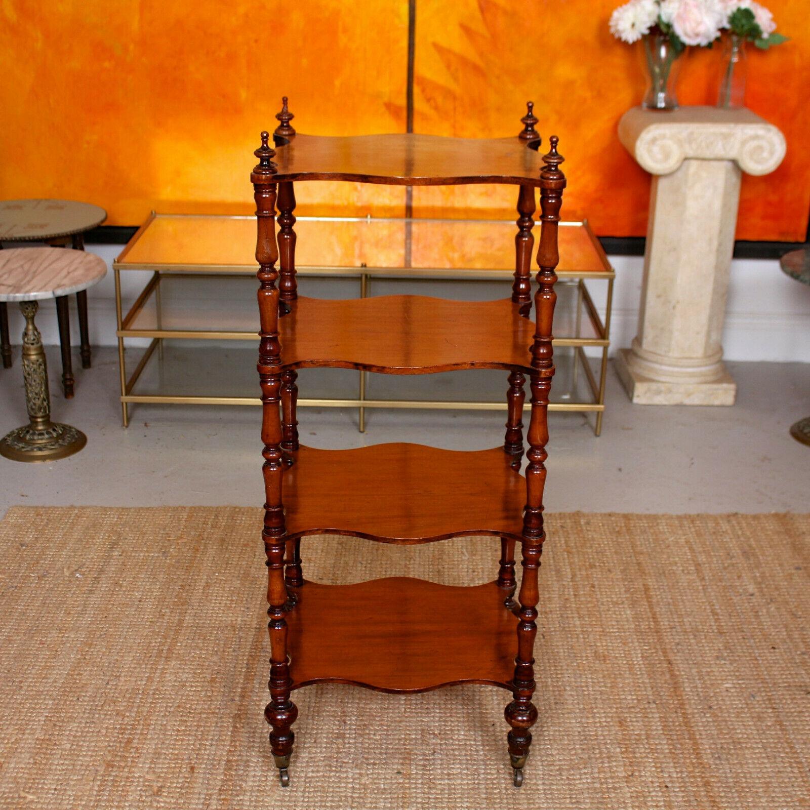 An impressive 19th century mahogany portable étagère whatnot.

The slender fluted turned supports united by four shaped shelves and raised on turned legs with brass capped
castors.
   