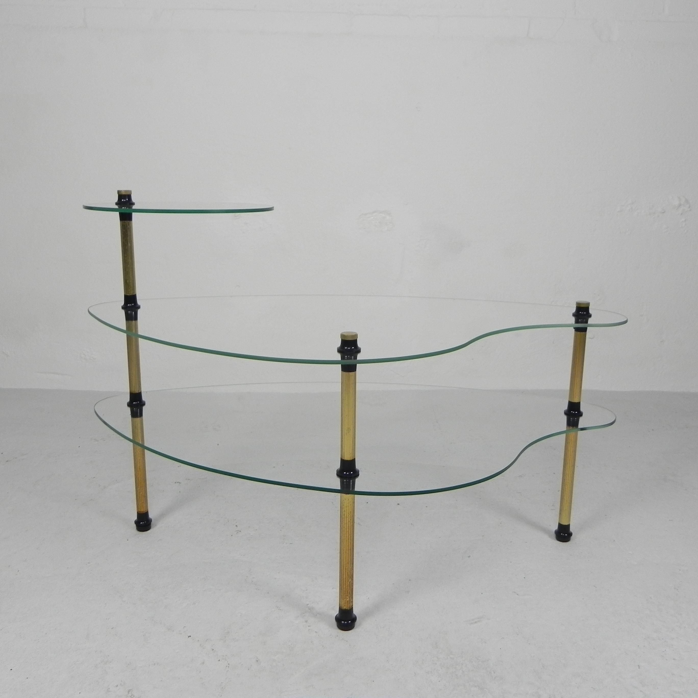 Three glass plates, 2 of which are kidney-shaped
and 1 round, resting on 3 legs.
The table can be dismantled completely.

Height: 54 cm.
Width: 080 cm.
Depth: 45 cm.
Origin: France, 1950s.
Material: glass / brass / plastic.