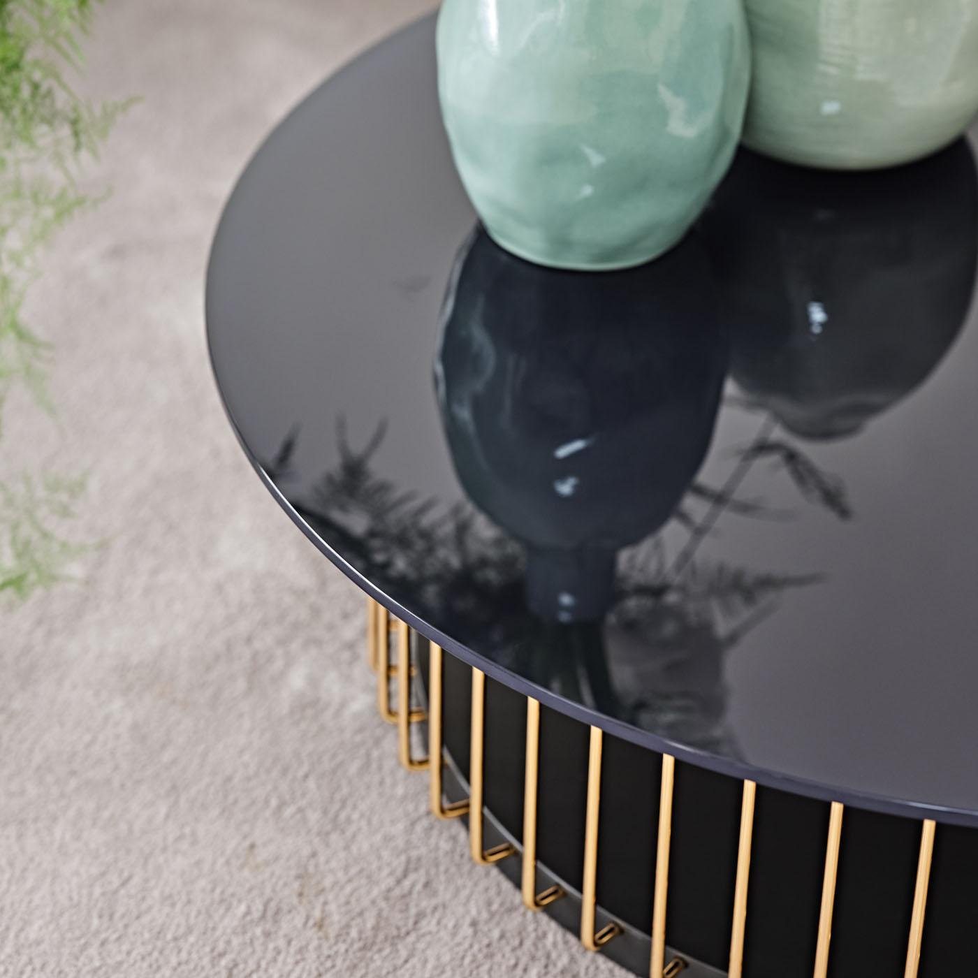 Refined and airy, this round coffee table is sure to infuse modern living sets with true elegance. Gleaming metal bars finished in glossy gold connect the round-cut matte-black MDF base to the circular glass top, which sports a sophisticated blue