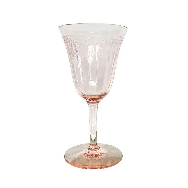 A set of seven peachy blush pink glass sherry or wine glasses. This beautiful set of glassware will be a fantastic addition to a bar or for when setting the table at a dinner party. Each glass is delicate and paneled or scalloped on the interior.