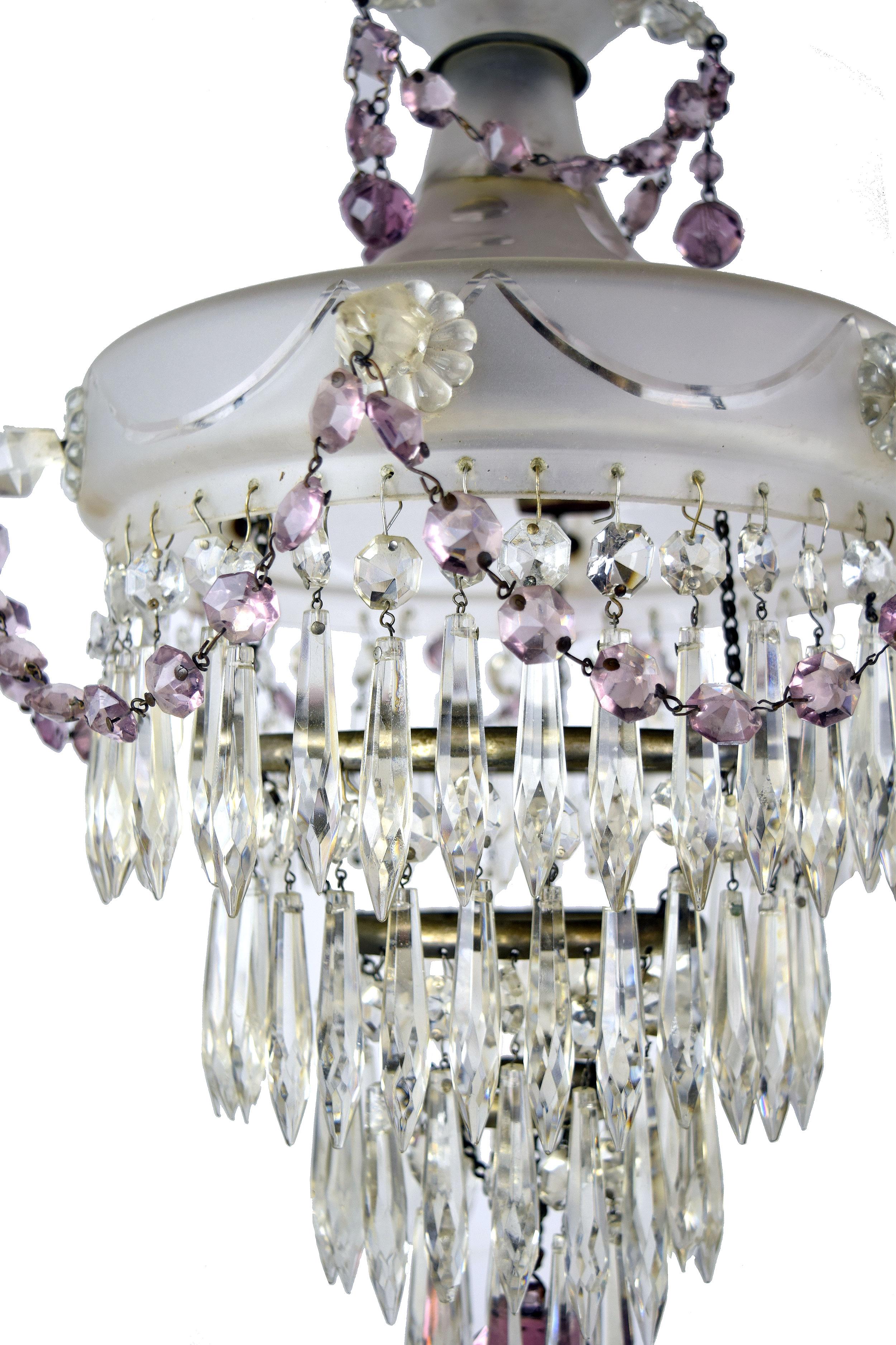 This elegant and simply gorgeous glass body chandelier features 4 tiers of dazzling crystals with eye-catching purple crystals intertwined. Roping of these lovely beaded crystals hang from the unique prism shaped glass that accents the bowl. The