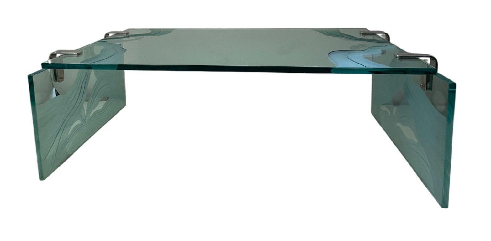 Elegant and refined, this etched glass coffee table in the style of Fontana Arte captures the essence of mid-century Italian design. Made in Italy circa 1960's, the table features three thick, etched glass panels joined together with four L-shaped