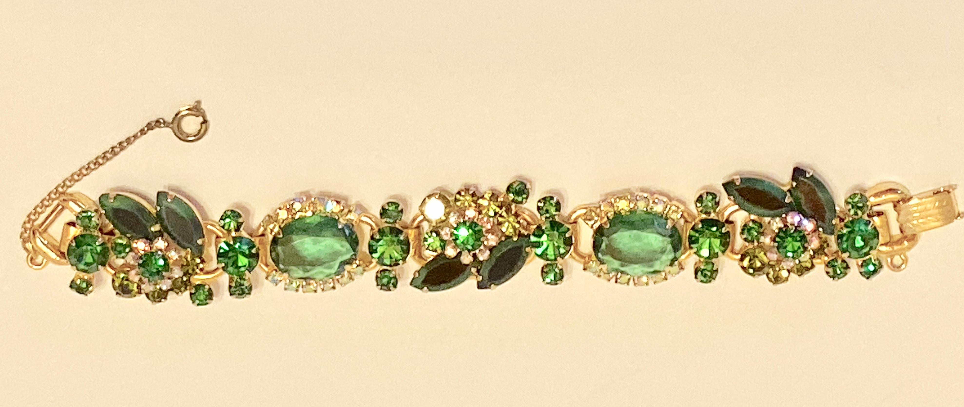      This wonderfully detailed costume etched vermeil gold hardware bracelet, has multi-sized emerald-green accented with iridescent inlay scattered into a floral setting. The bracelet  is supported with a safety chain measuring 2 inches in length.