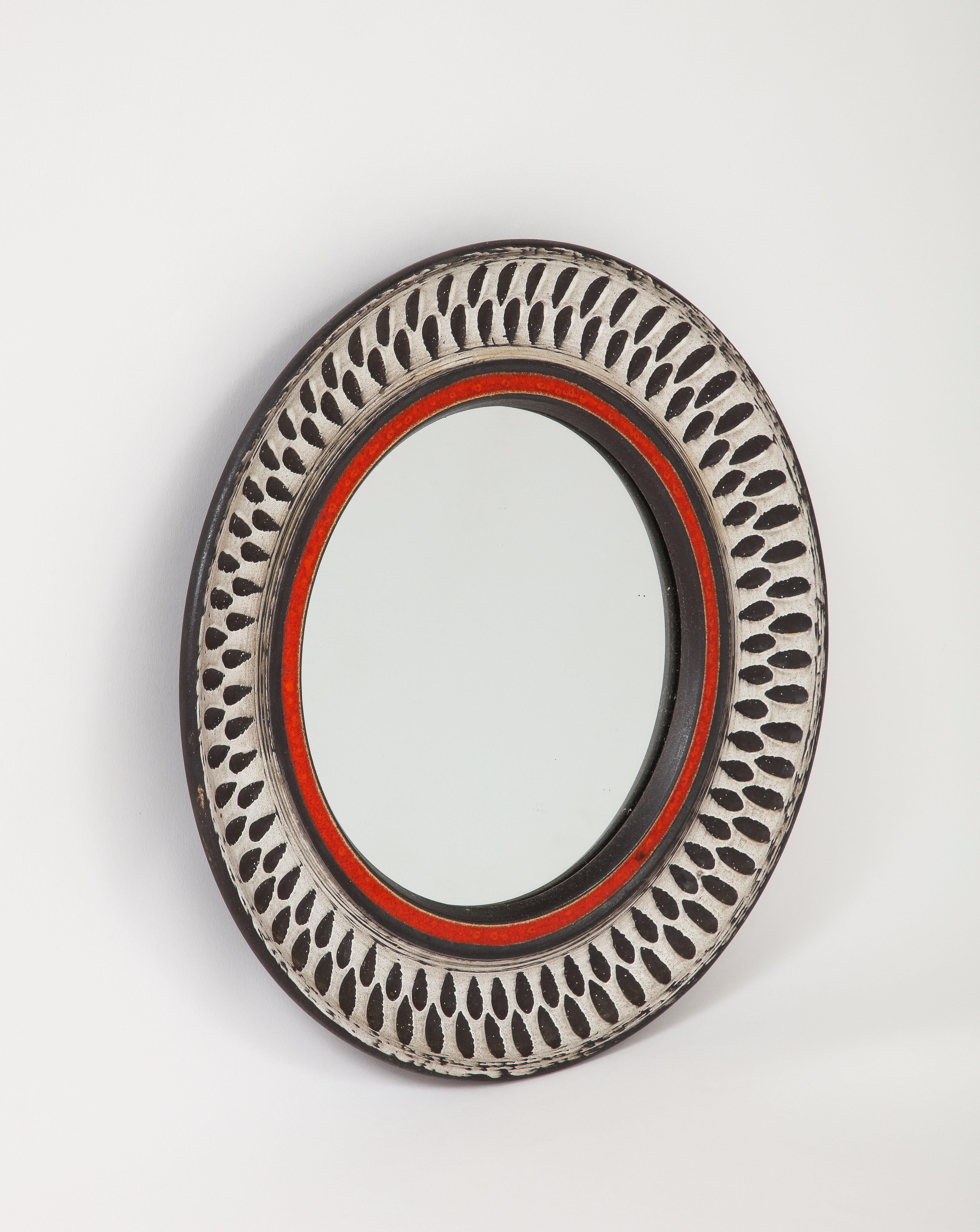 Elegant miroir mural de petite taille de forme ronde. Peut-être de Vallauris. Céramique gravée.
En bon état vintage.