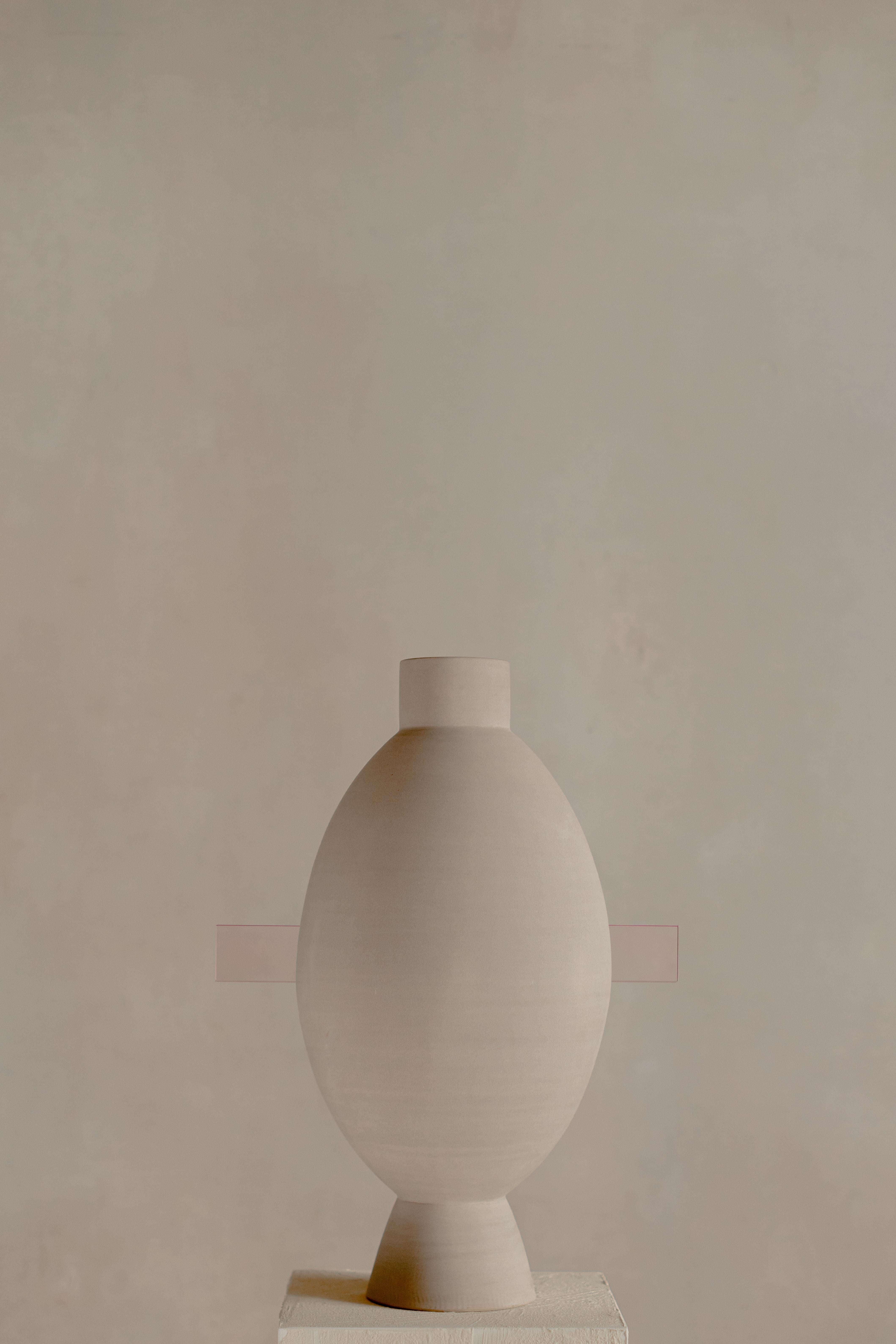 Hender HENDER 04 est un objet de collection qui incarne la tension tranquille entre la matière brute et la forme raffinée. Fabriquée entièrement à la main, sa base est façonnée à partir d'argile péruvienne tournée selon des méthodes traditionnelles