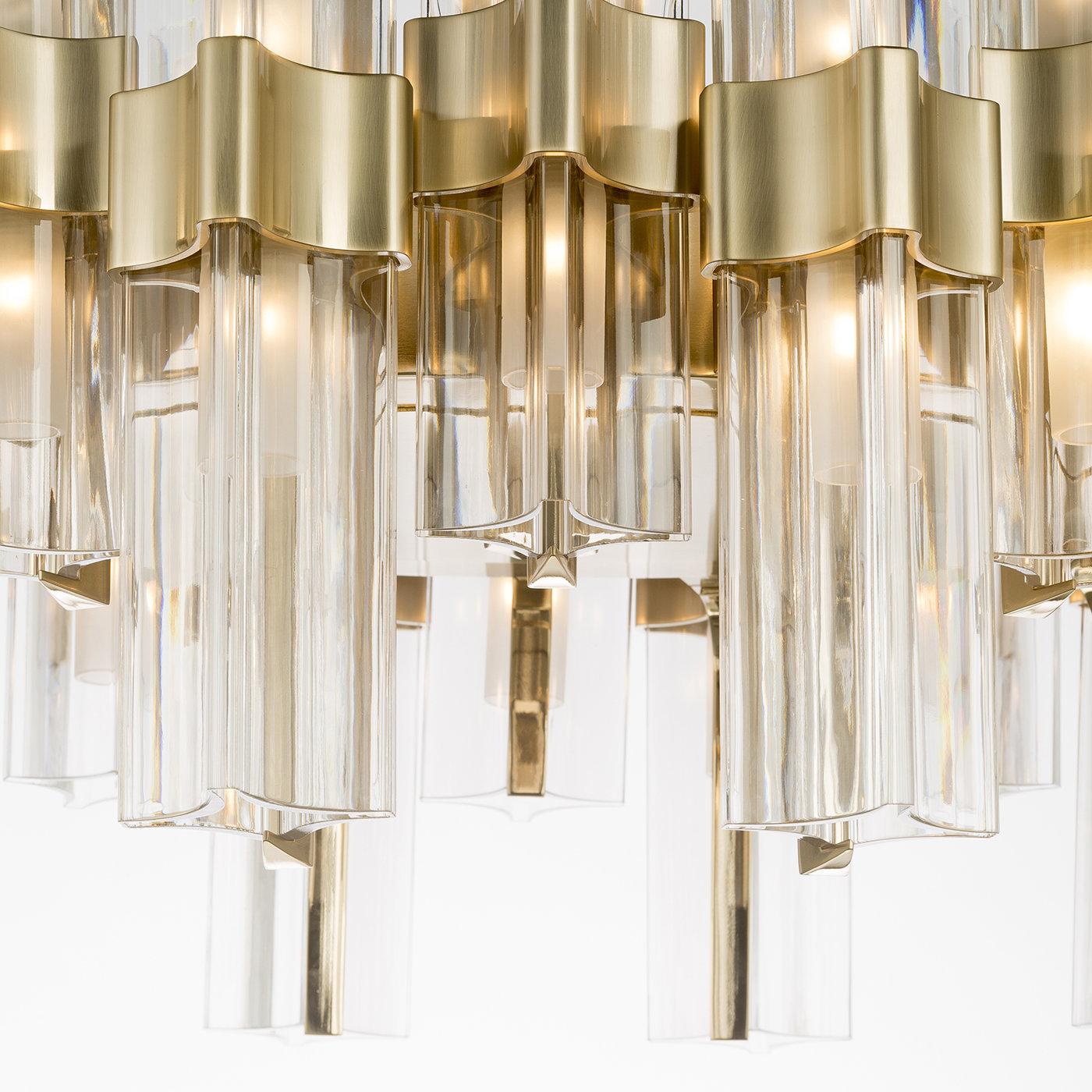 This stunning pendant light will illuminate any space. Crystal shades with metal accents, arranged in a circular form, hang off double metal arms for a contrast in form and materials in this piece, part of the Eterea collection, that is a triumph of