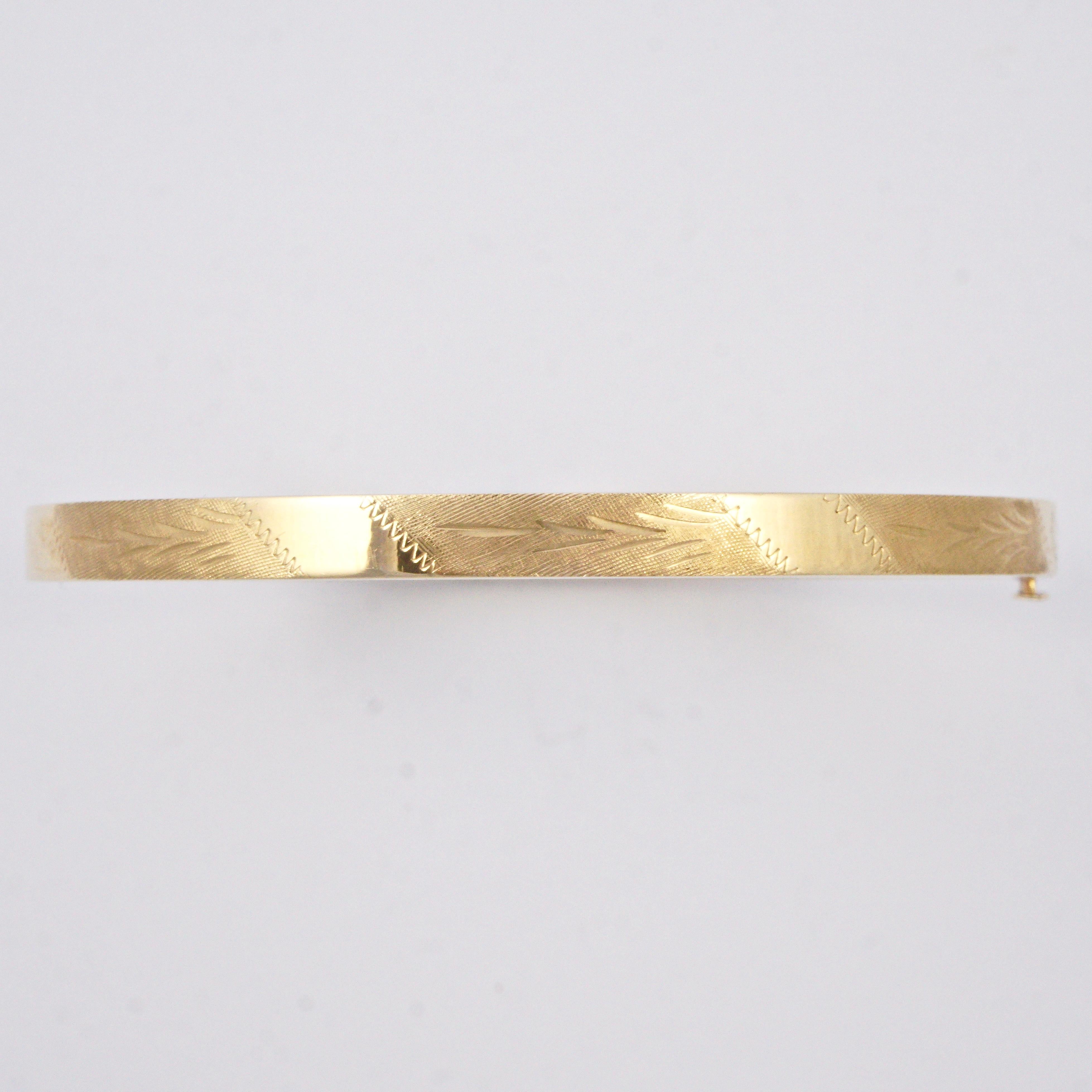 EternaGold 14K gold Costa Rica bangle, featuring a textured leaf design. The bangle is slightly oval measuring 6.4cm / 2.5 inches by 5.9cm / 2.3 inches diameter, the width is 4.5mm / .17 inch. It opens with a push button and has an internal bar for