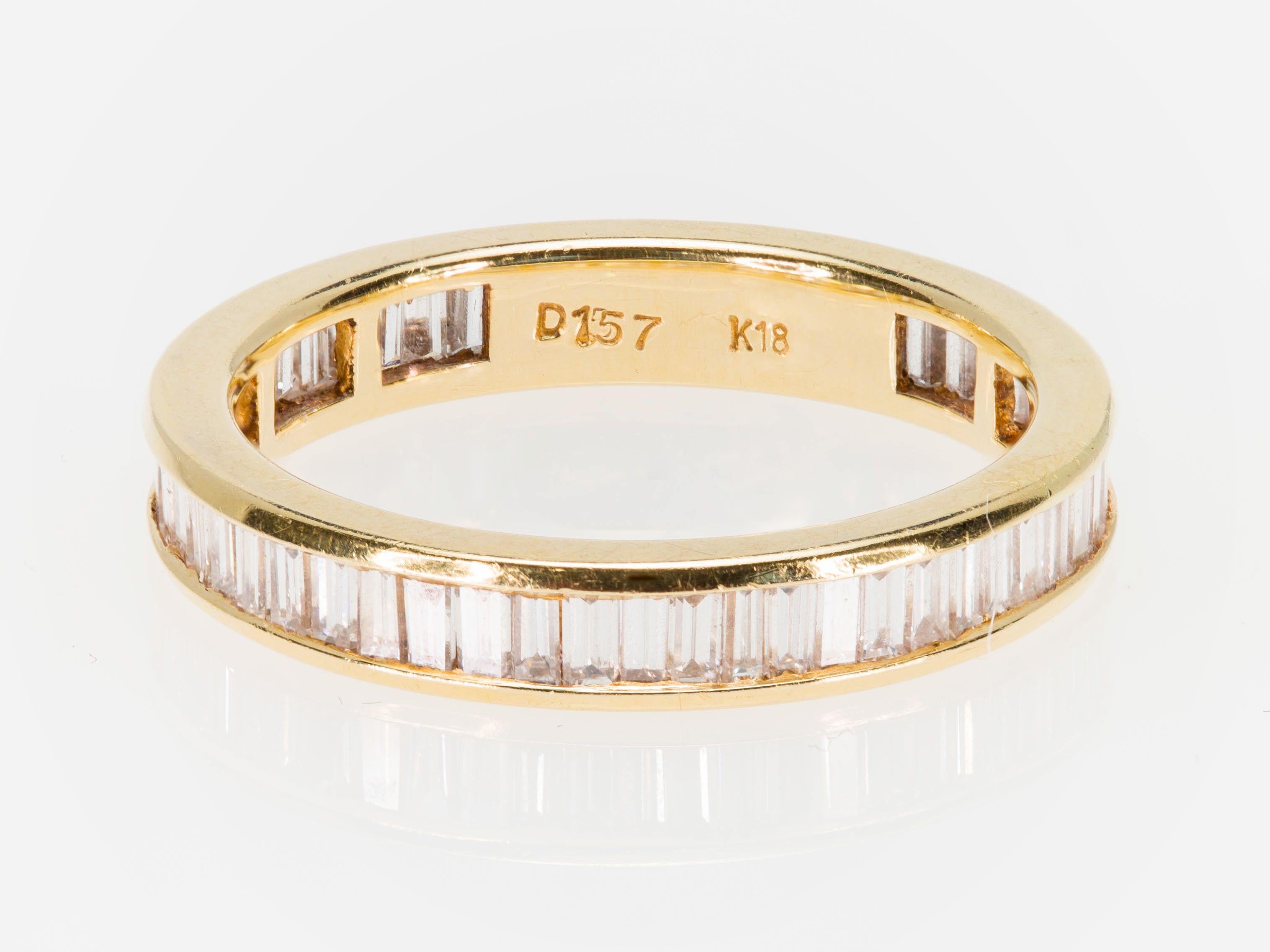 An American Eternity baguette cut Diamond band ring circa 1980 in 18K yellow gold, size 6 ¾. This Eternity band wedding ring features baguette-cut Diamonds of an approximate total weight of 1.57 carats. The diamonds grade is IJ color and VS-SI