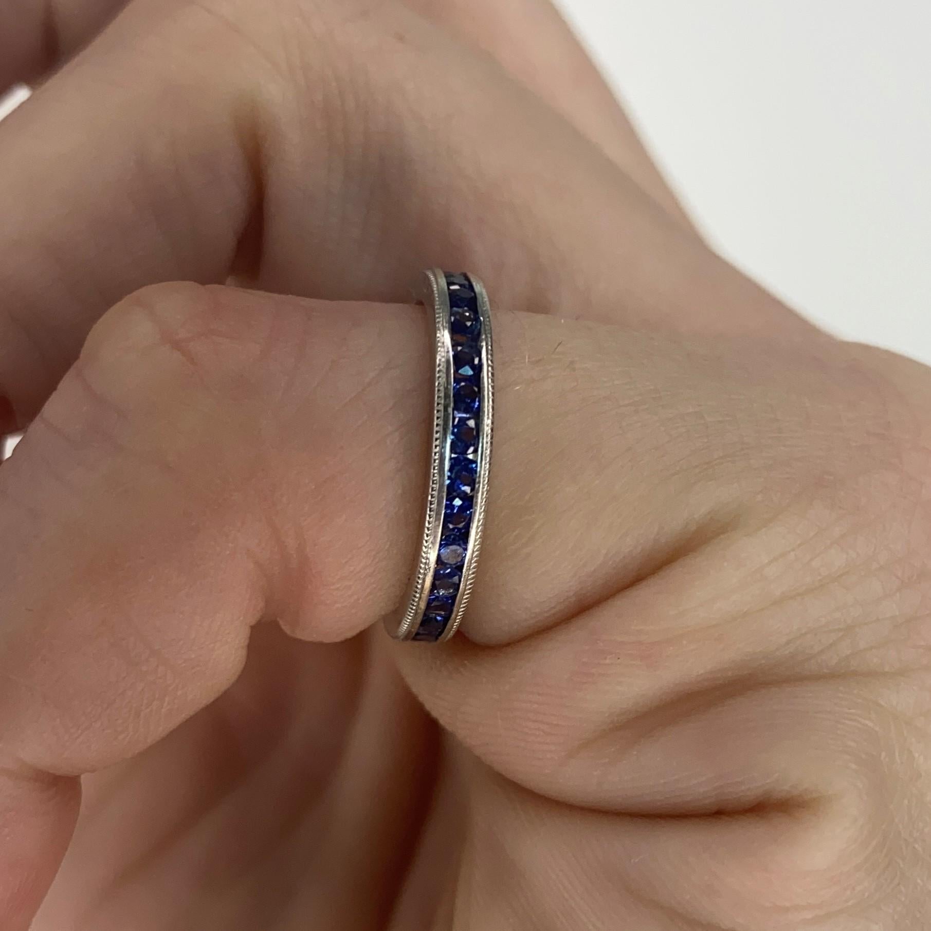 An eternity ring band with natural sapphires.

Contemporary eternity band ring crafted in America in solid white gold of 18 karats with high polished finish. It is mounted in a plain channel setting with 30 calibrated round brilliant cuts of blue