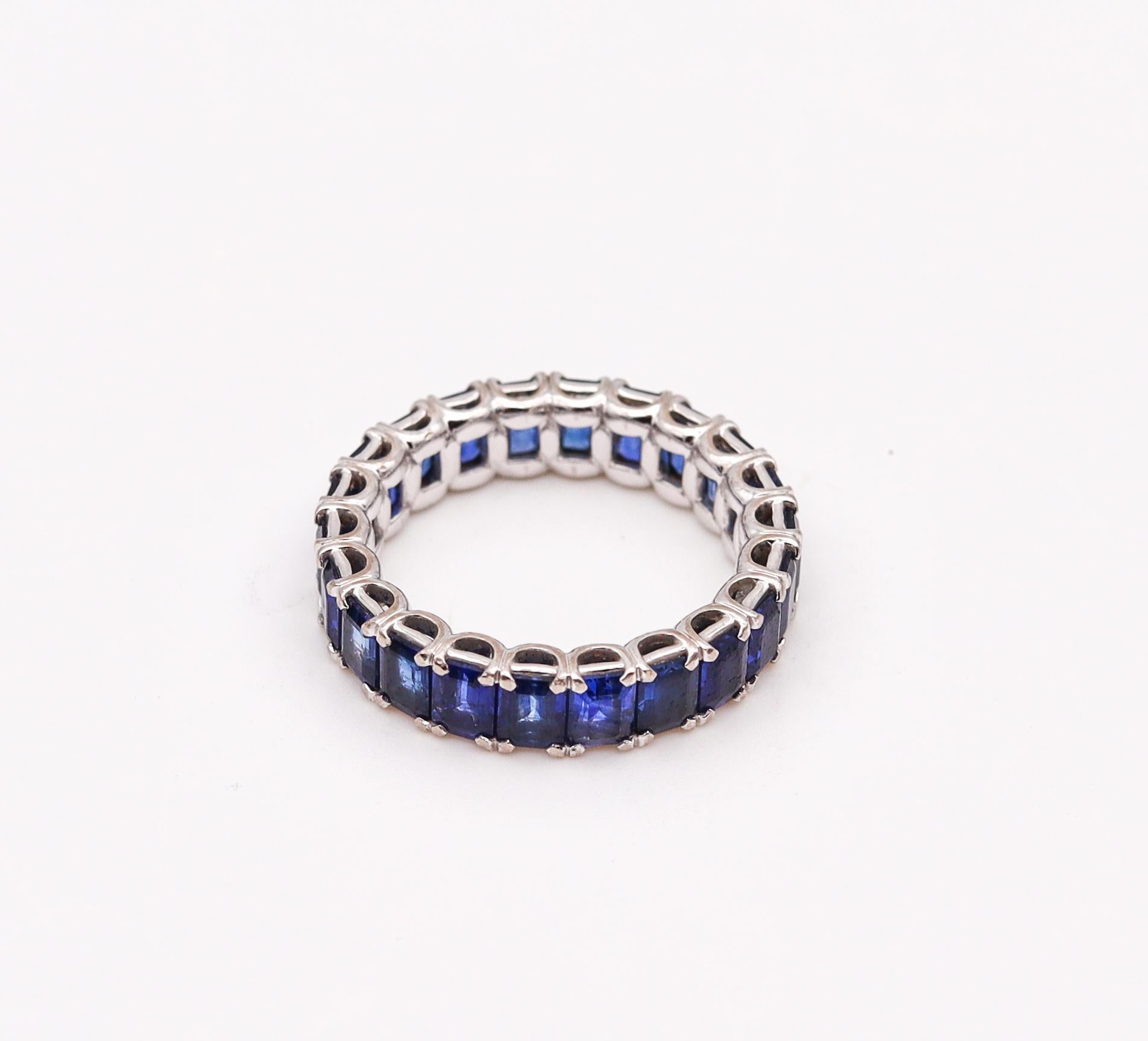 An eternity ring band with natural sapphires.

Contemporary eternity band crafted in America in solid white gold of 18 karats with high polished finish. It is mounted in four-prongs settings with 22 calibrated emerald cornered cuts of blue