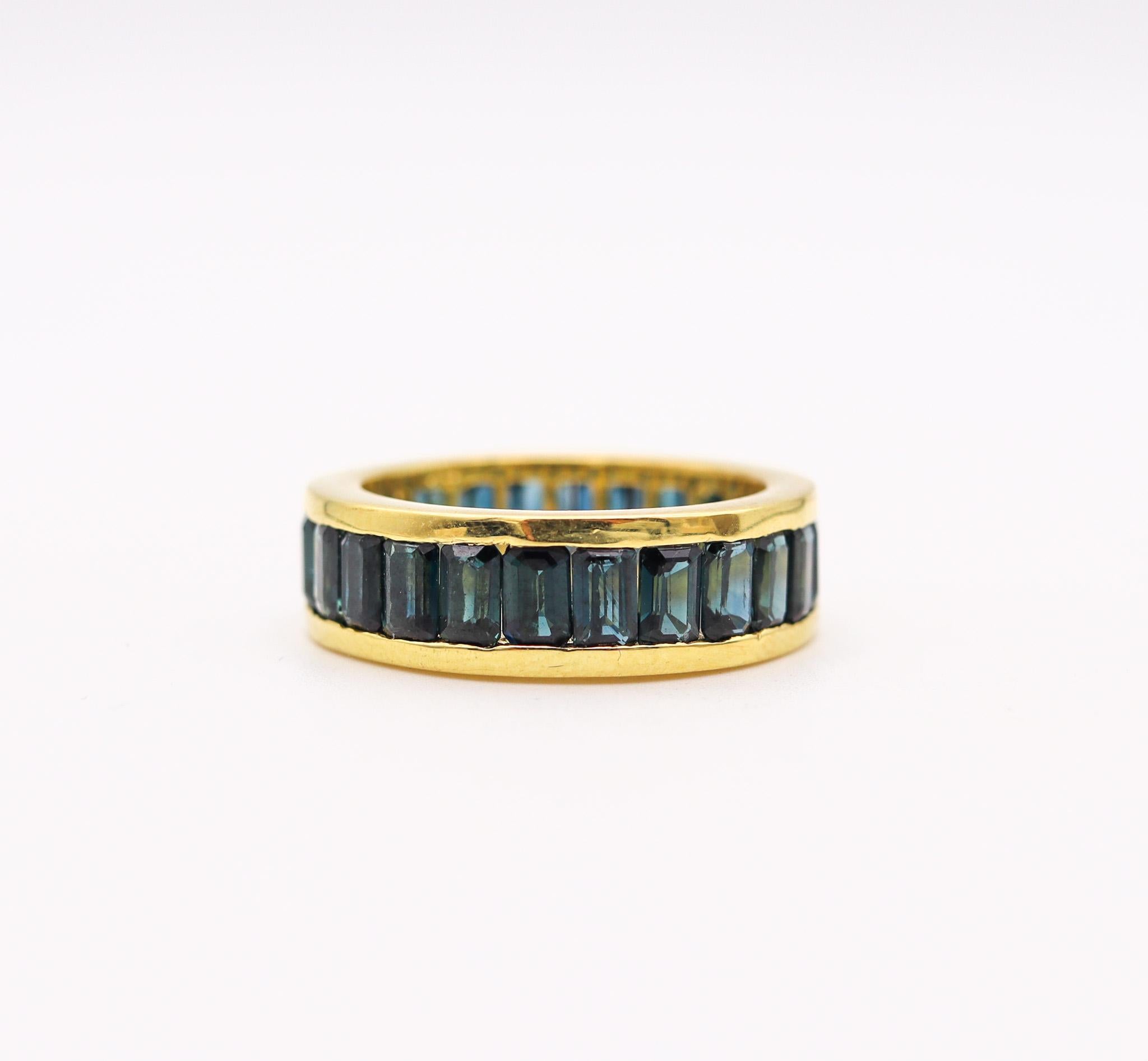 An eternity ring band with Natural Sapphires.

Modern eternity band ring crafted in solid 18 karats white gold, with high polished finish. Designed with a bold and thick look and is mounted in a channel-setting, with 24 calibrated emerald cuts of