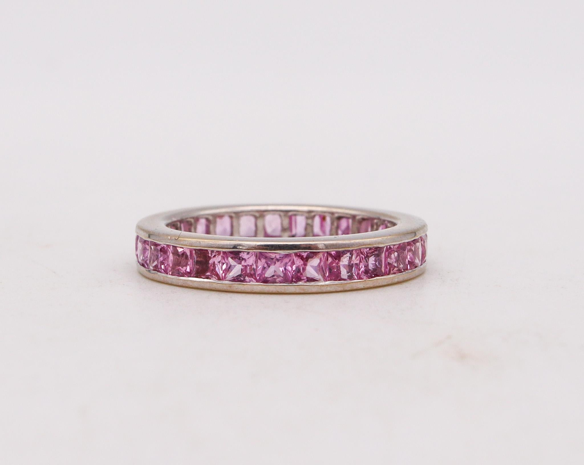 An eternity ring with Pink Sapphires.

A classic modern full eternity band carefully crafted in solid white gold of 18 karats, with high polished finish.

Pink Sapphires: Mounted in a channel setting, with 27 calibrated French squared steps cuts of