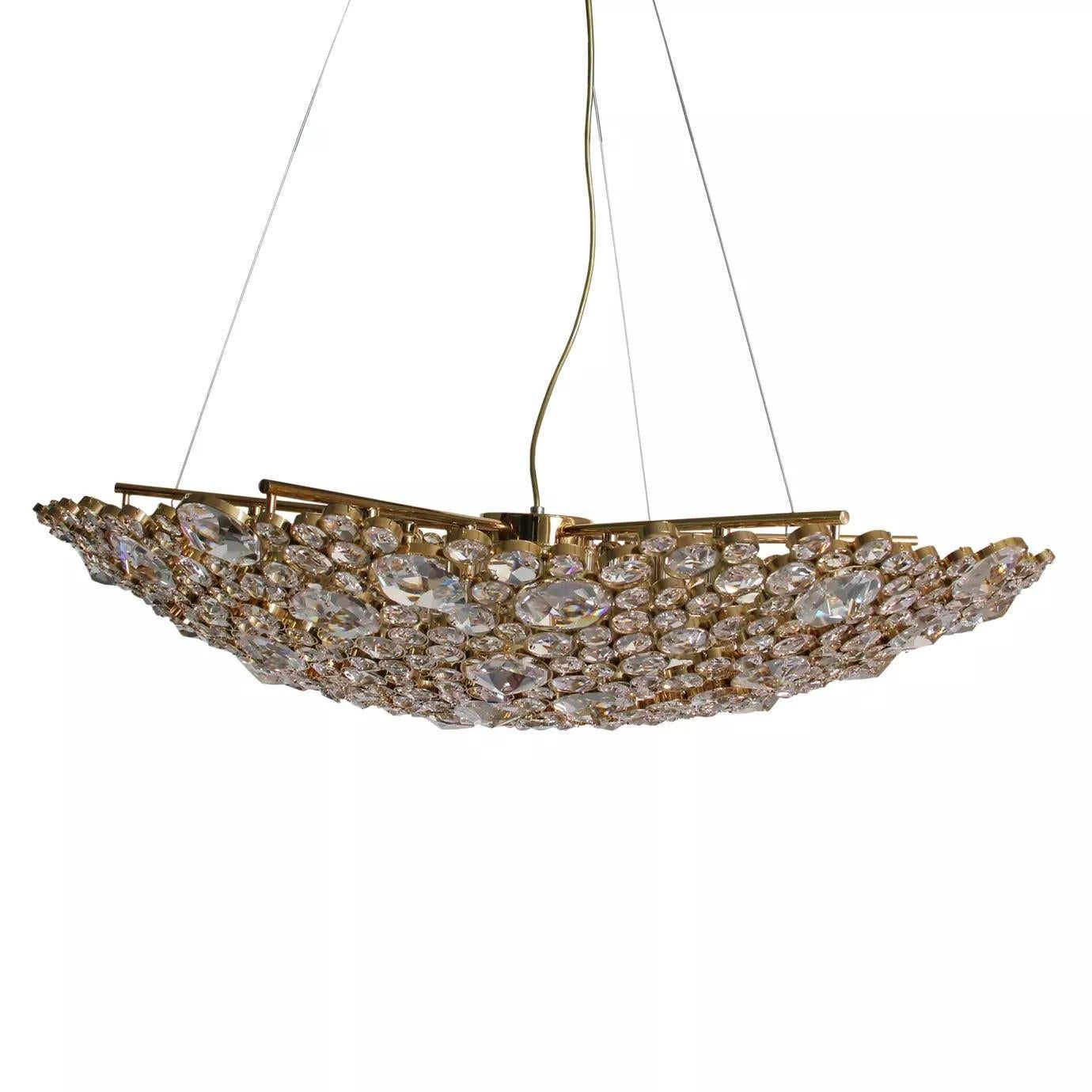 The elegant silhouette of this chandelier takes its brilliance from the skillful application of the crystal. The eternal circles are individually wrapped in brass and placed with astonishing attention to detail. The end result is an extraordinary