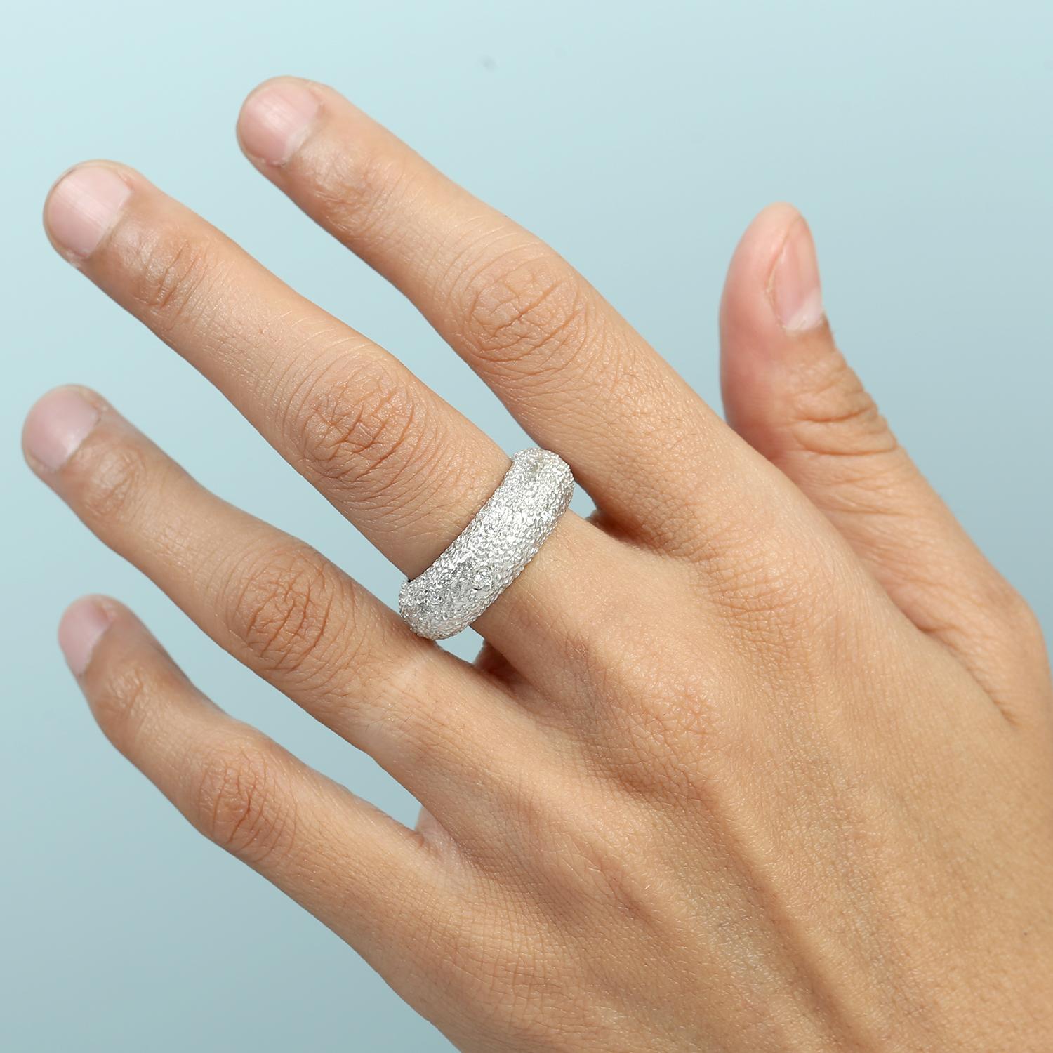 Questa fascia per l'eternità unisce la brillantezza classica al fascino artigianale, con una texture martellata che aggiunge profondità e unicità all'oro bianco 14k. Una linea continua di diamanti ne esalta l'eleganza, rendendolo perfetto sia per