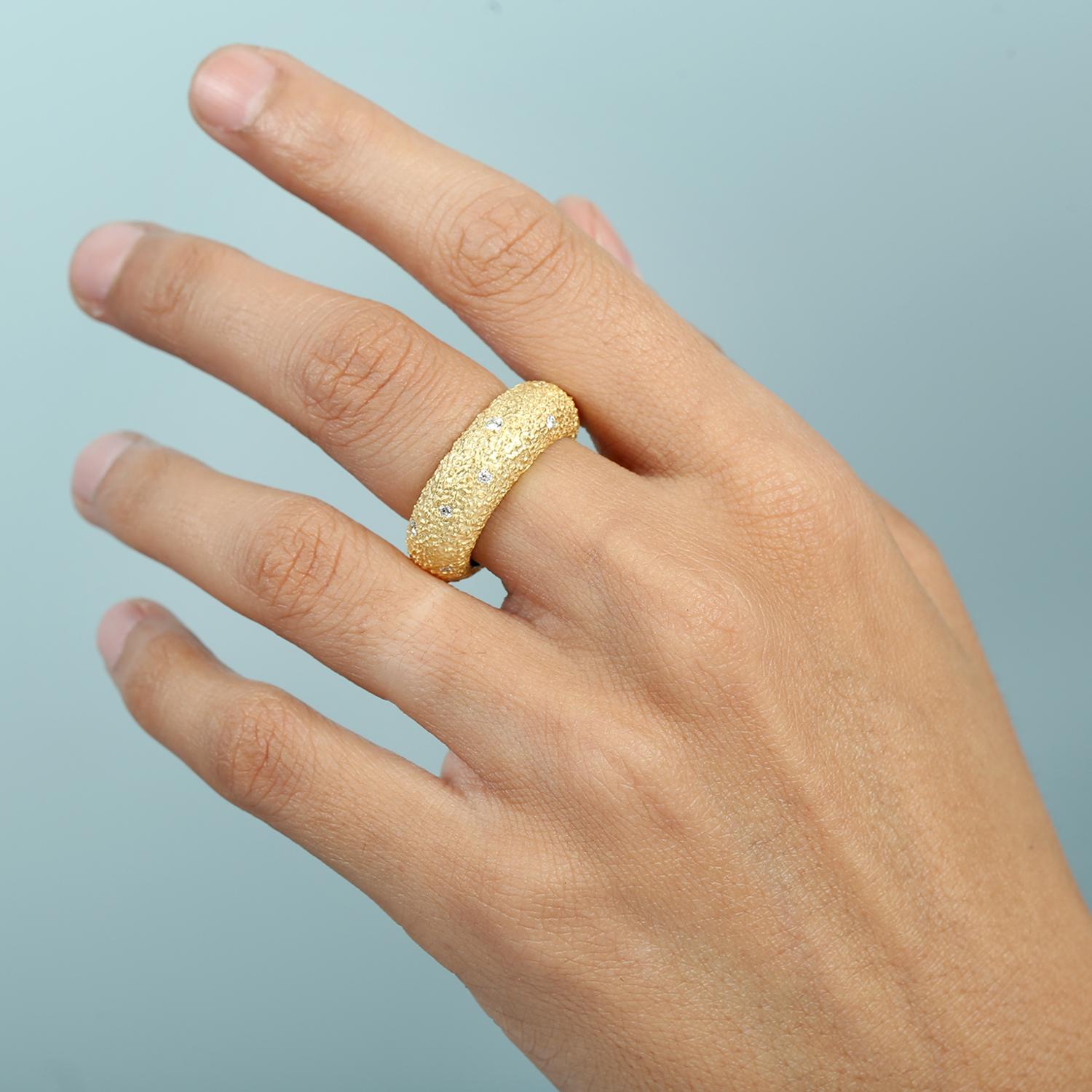Realizzata in ricco oro giallo 14k, questa fascia per l'eternità presenta una finitura martellata che aggiunge un carattere raffinato e artigianale. La fila continua di diamanti dona uno scintillio senza tempo, rendendolo una scelta versatile per