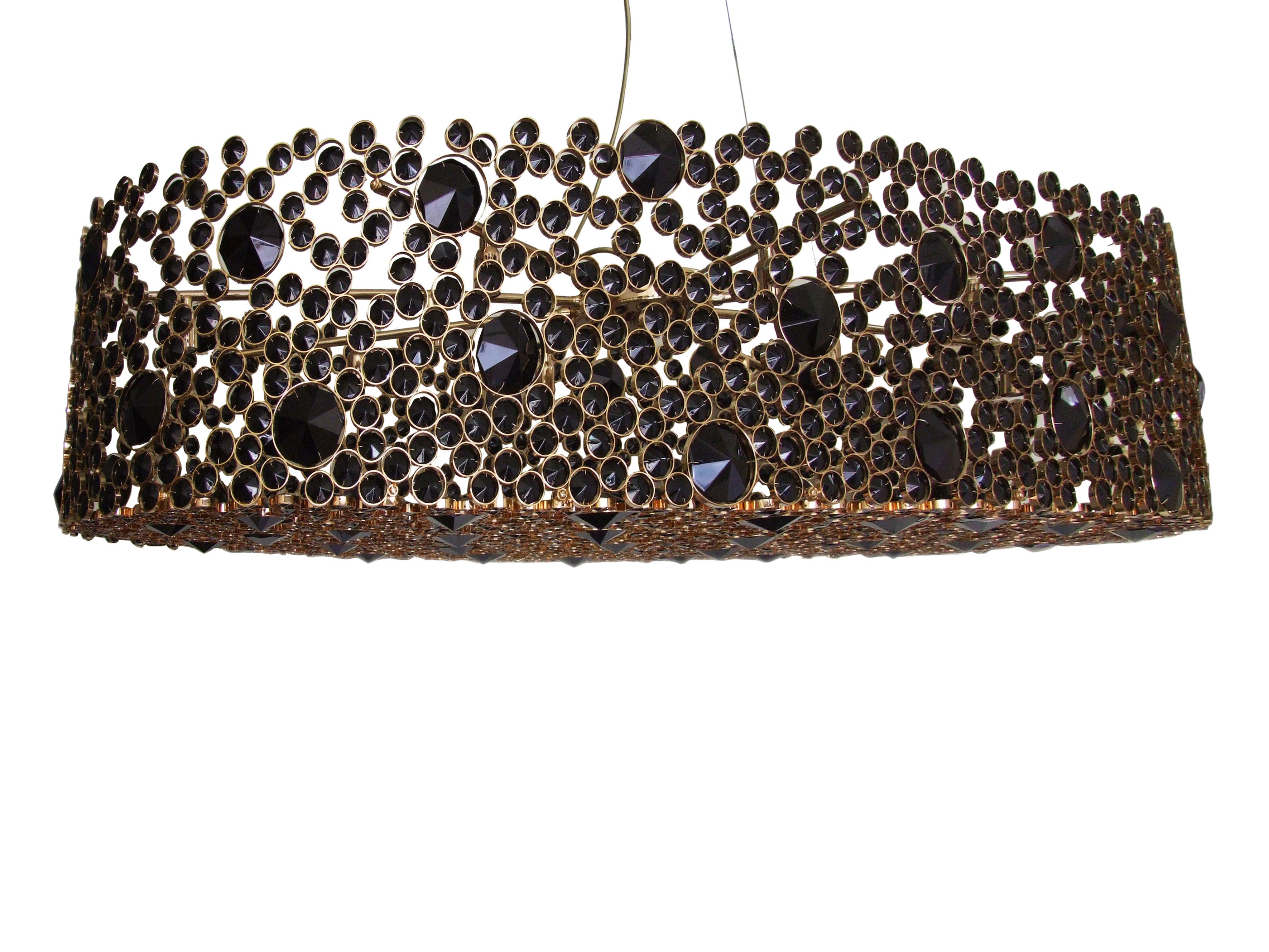 The elegant silhouette of this chandelier takes its brilliance from the skillful application of the crystal. The eternal circles are individually wrapped in brass and placed with astonishing attention to detail. The end result is an extraordinary