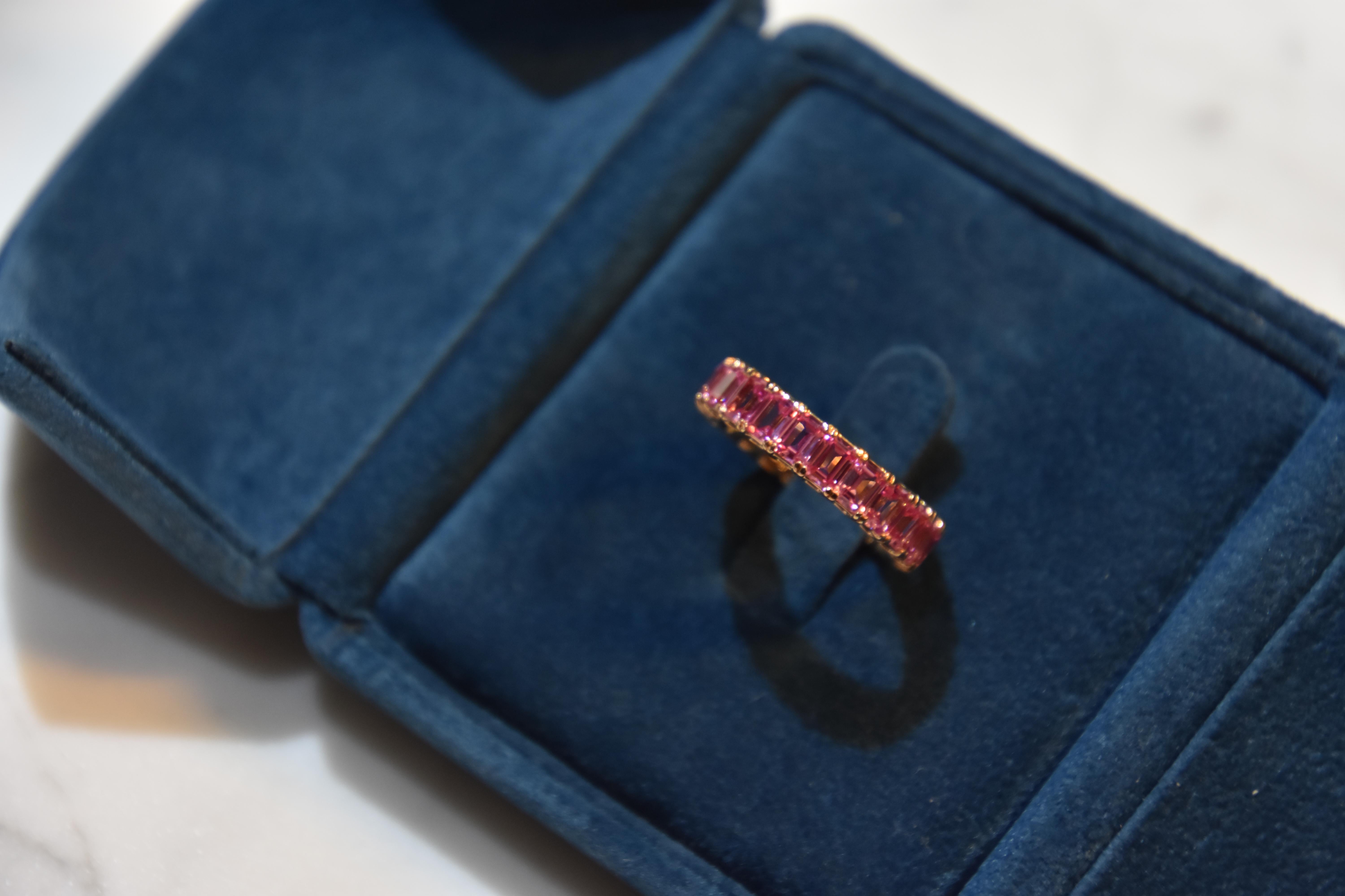 Each pink sapphire stone 0.24 carat. Total 22pcs/  5.21 carat pink sapphire Eternity Ring set in 18K rose gold. You can order your own size. It takes around 4 weeks for delivery. 
Ring size- US 6.25,   Kahn also provide engraving, resizing and