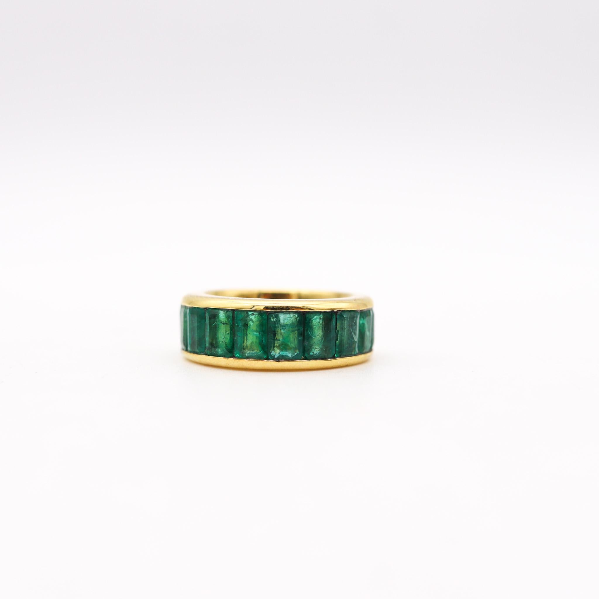 An eternity ring band with Natural Emeralds.

Modern eternity band ring crafted in solid yellow gold of 18 karats white gold, with high polished finish. Designed with a bold and thick solid look and  mounted in a channel-setting, with 12 calibrated