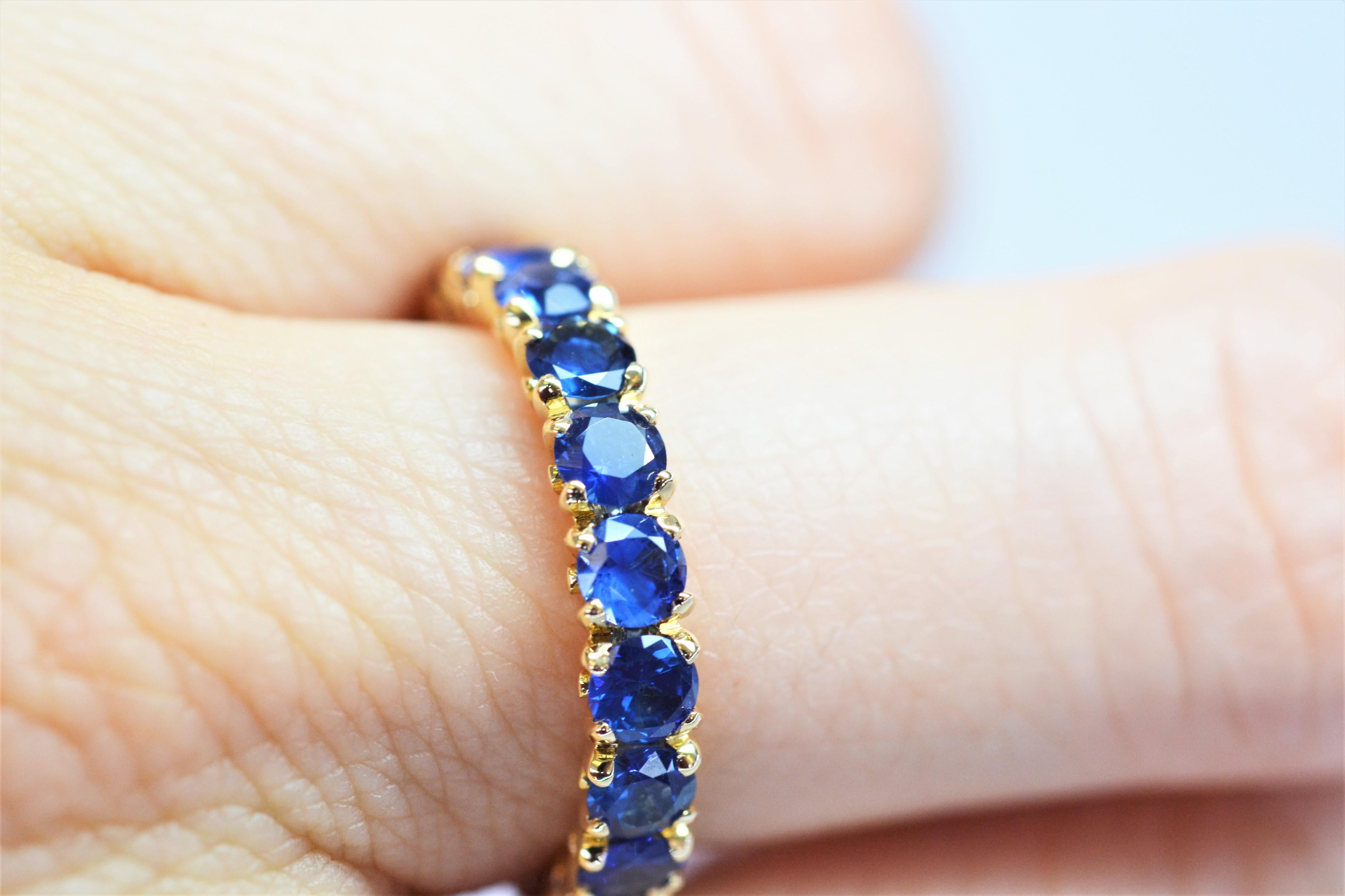 Questo elegante anello eternità con fiore unisce bellezza e stile. Può essere indossato sia con disinvoltura che in modo più formale e può essere indossato da solo o sovrapposto ad altri anelli. Gli zaffiri blu reali sono incastonati in oro giallo