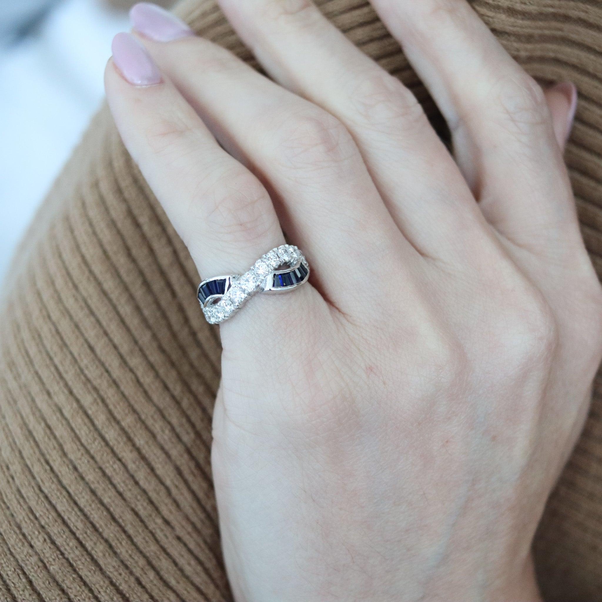 Ein wirbelnder Ewigkeitsring mit Saphiren und Diamanten.

Dies ist ein schöner modernistischer Ewigkeitsring mit vier symmetrischen Stationen aus massivem 18-karätigem Weißgold mit hochglanzpolierter Oberfläche. Der Ring ist mit einer großen Auswahl