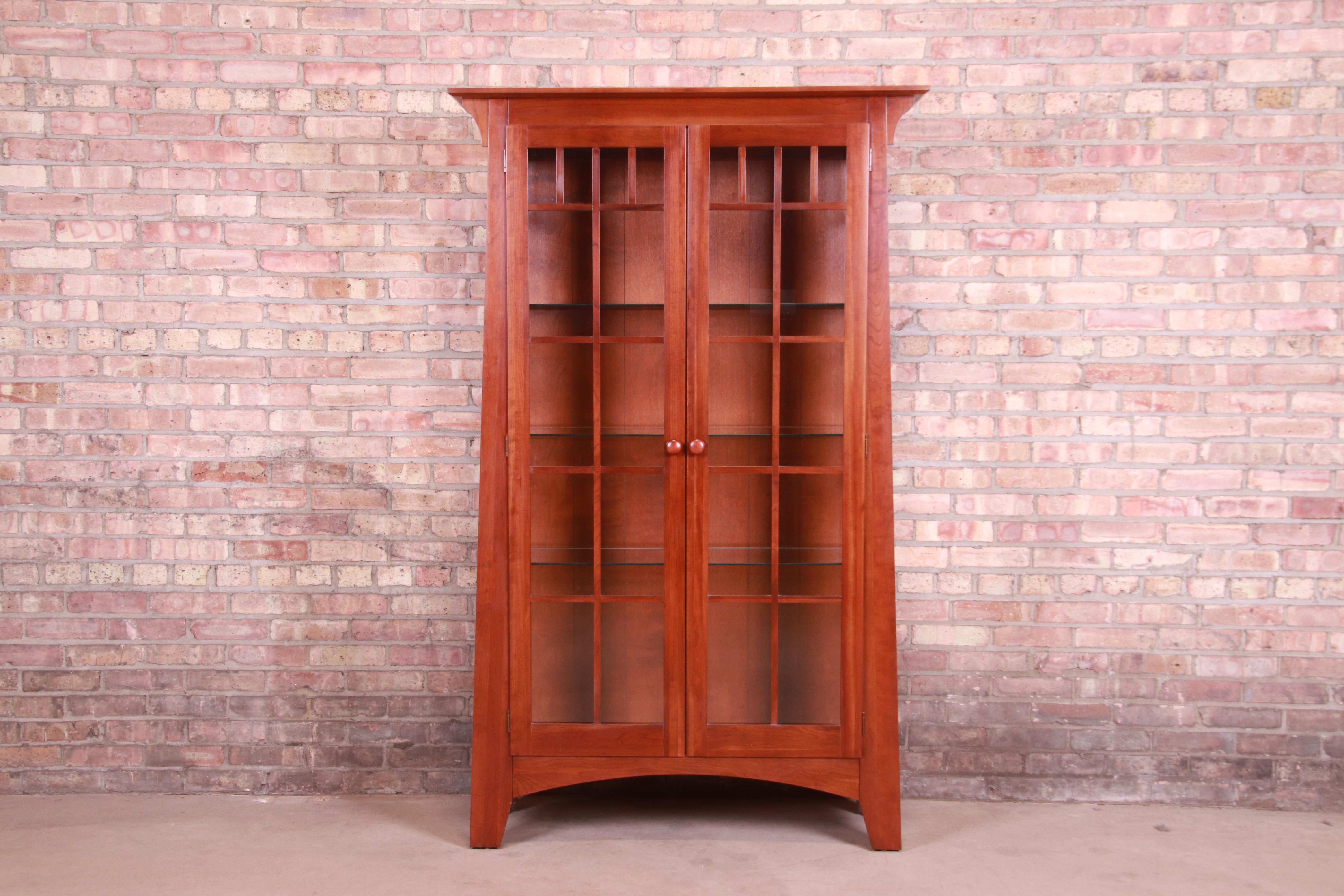 A gorgeous Mission or Arts & Crafts style lighted display cabinet or bookcase

In the manner of Gustav Stickley or Harvey Ellis

By Ethan Allen

USA, Circa 1990s

Solid cherry wood, with mullioned glass front and sides.

Measures: 43.13