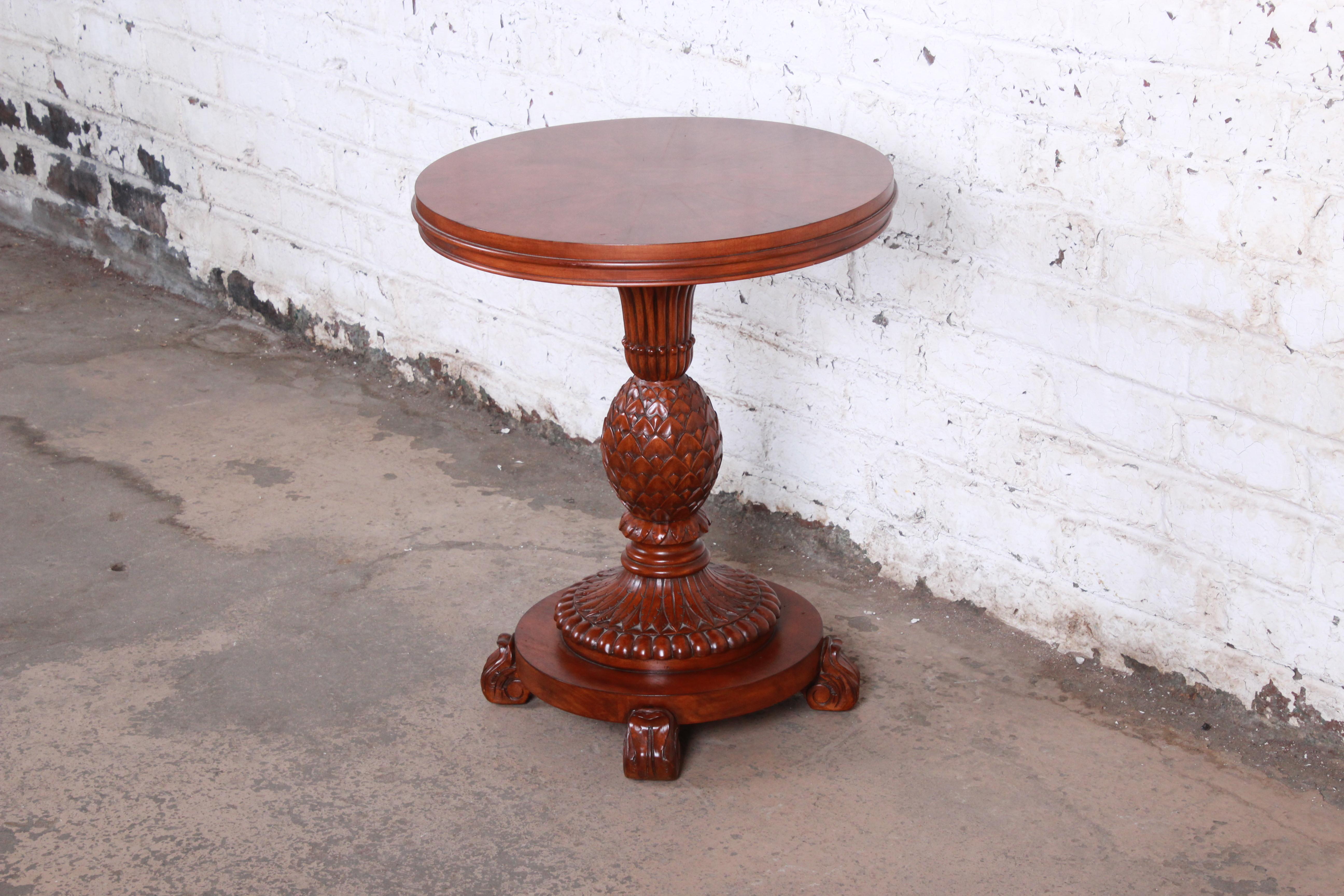 A gorgeous carved mahogany pedestal side table or plant stand by Ethan Allen. The table features beautiful mahogany wood grain with a unique inlaid starburst pattern on top and a beautiful carvings in a pineapple motif. Made with the highest quality