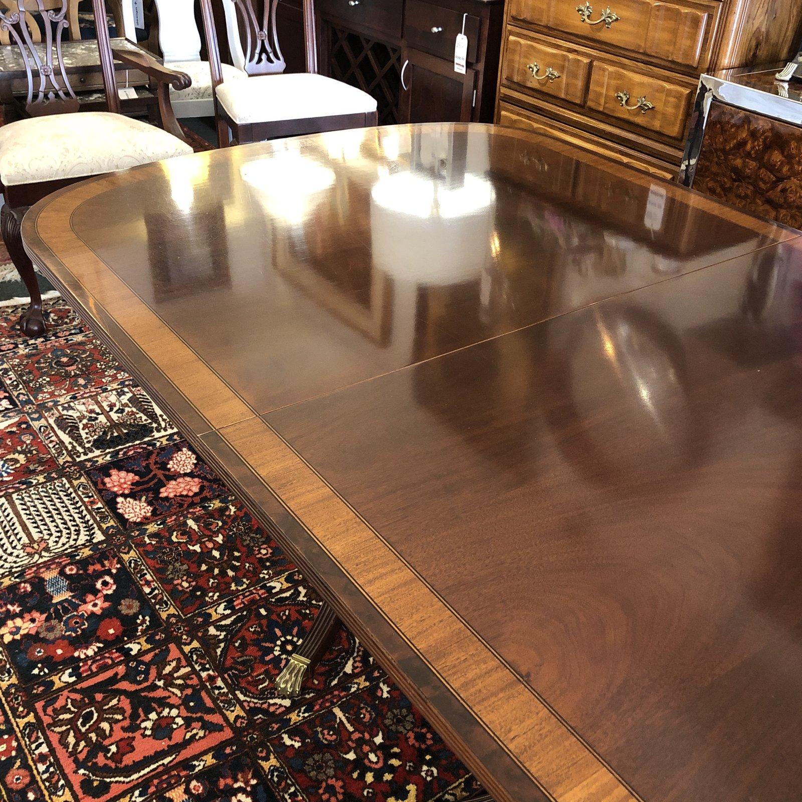 A classic dining set by Ethan Allen. An elegant reproduction, this 18th century inspired set includes a double pedestal table. Lovely curves, contrasting inlaid woods, brass toecaps and turned bases are just the beginning of the details that speak